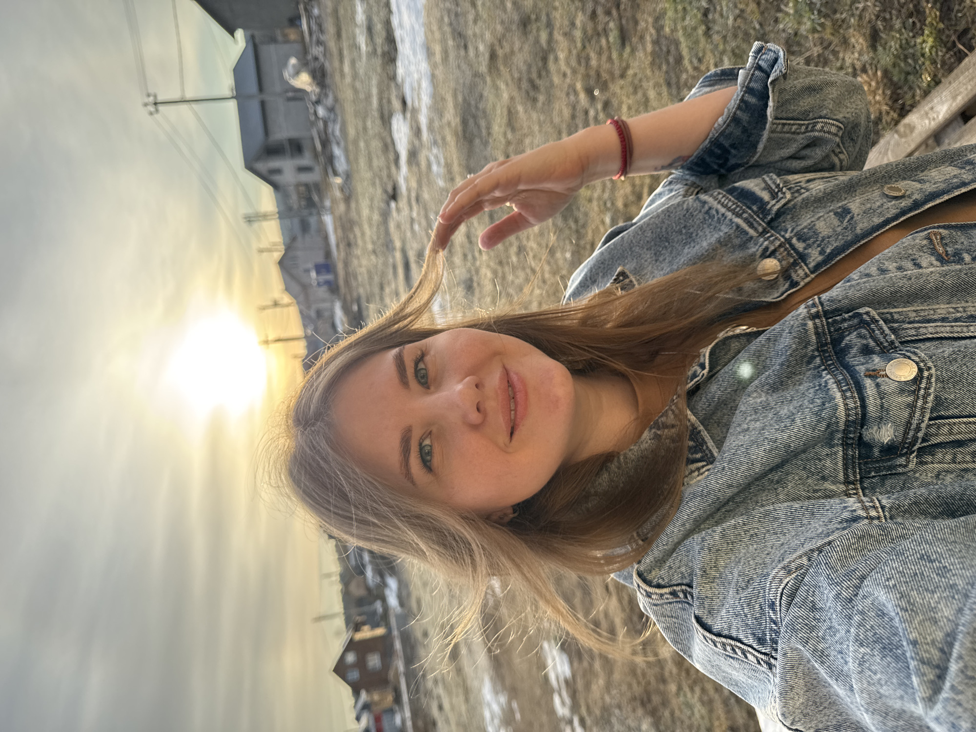 Woman takes sunny selfies on bench in Russian town