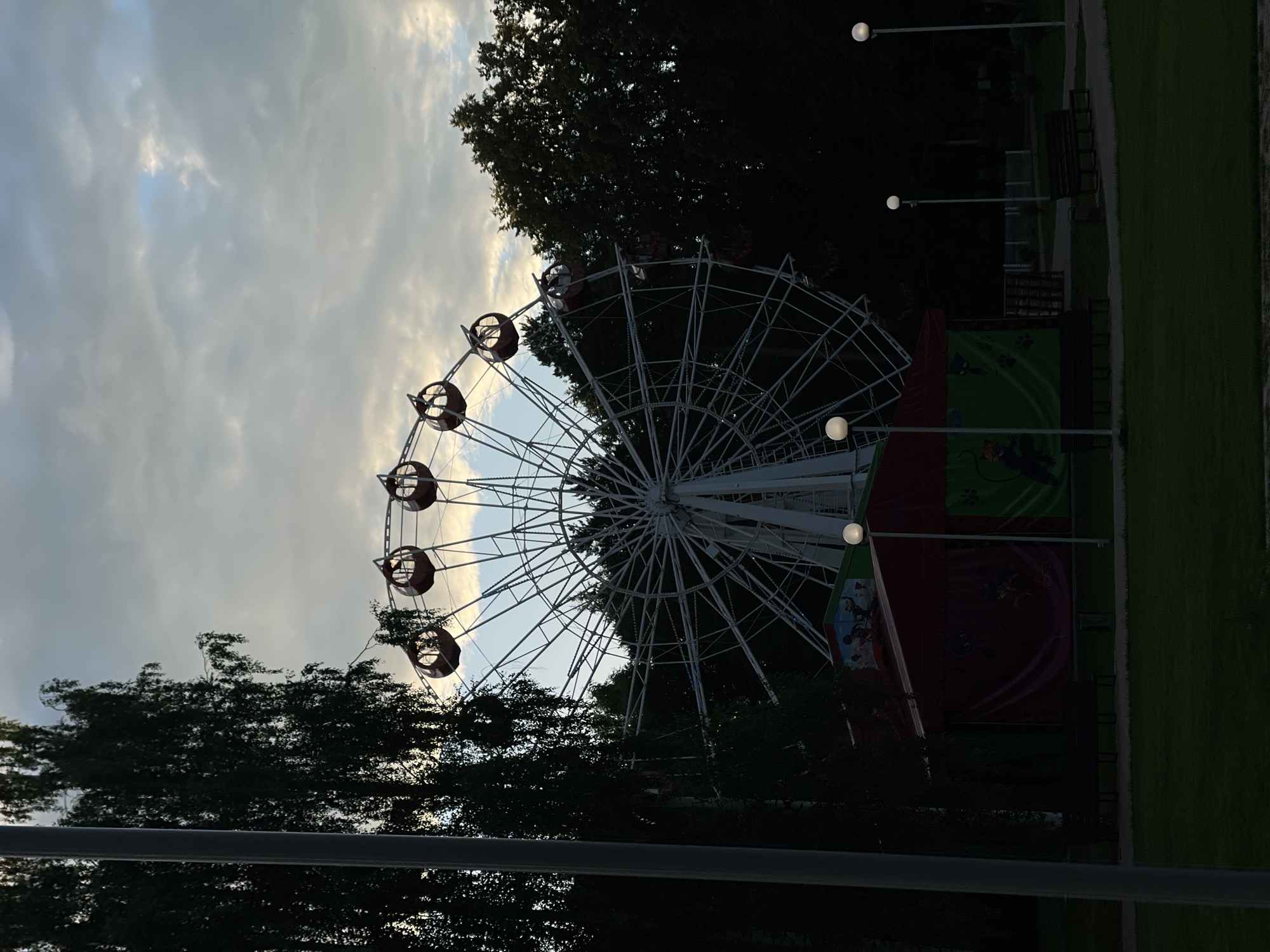 Fairground rides, street food, and carnival stalls on a cloudy afternoon.