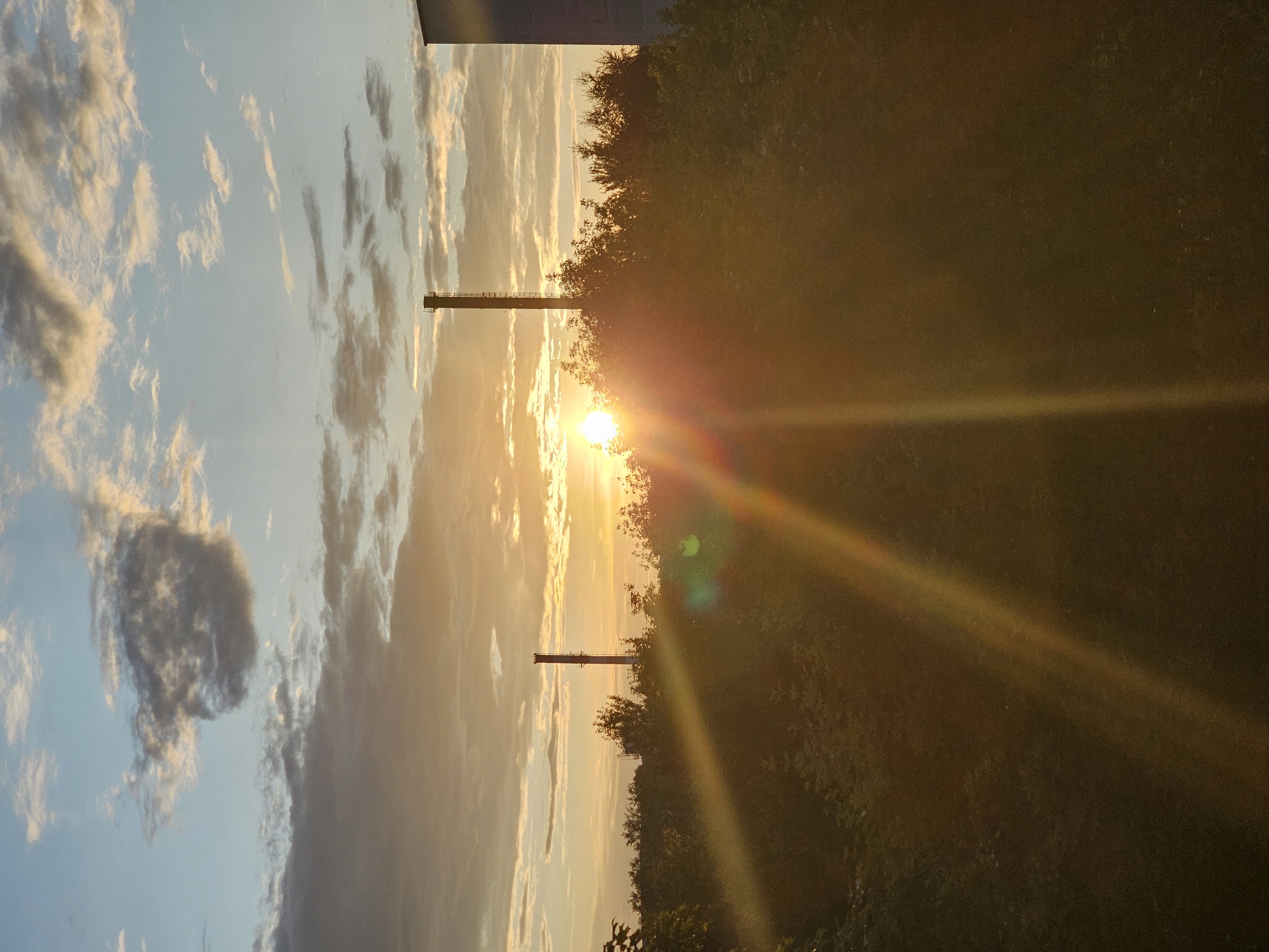 Golden sunset over Khimki, framed by chimneys and trees