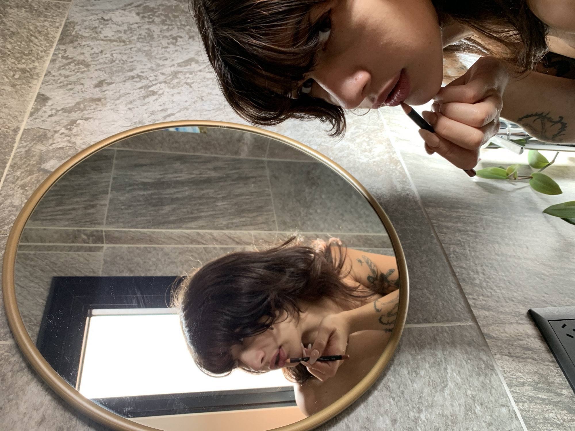 Woman applies makeup in mirror in Buenos Aires