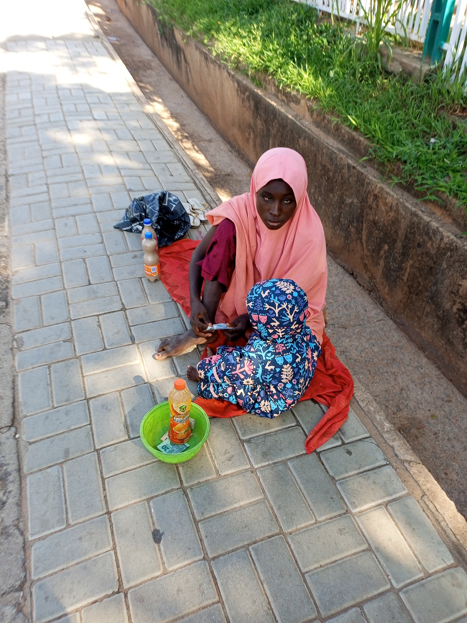 Morning street life along Gombe's sidewalks and drainage paths
