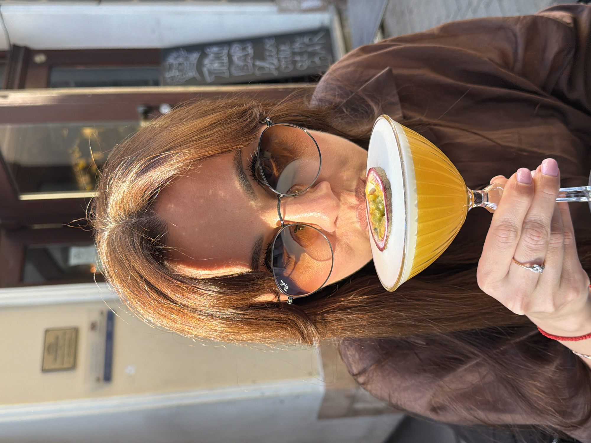 Woman enjoys cocktails outdoors in sunny Riga afternoon
