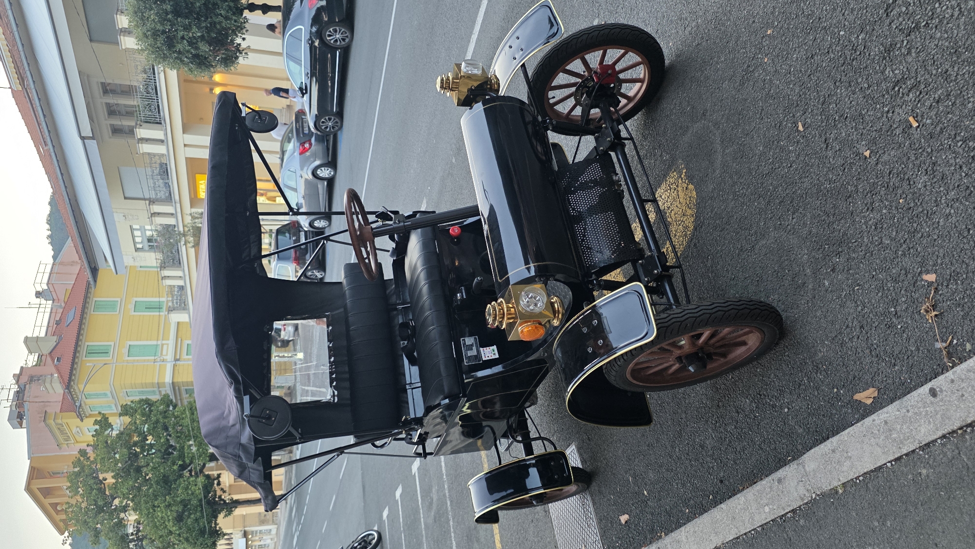 Vintage car and a street stroll near colorful building facades