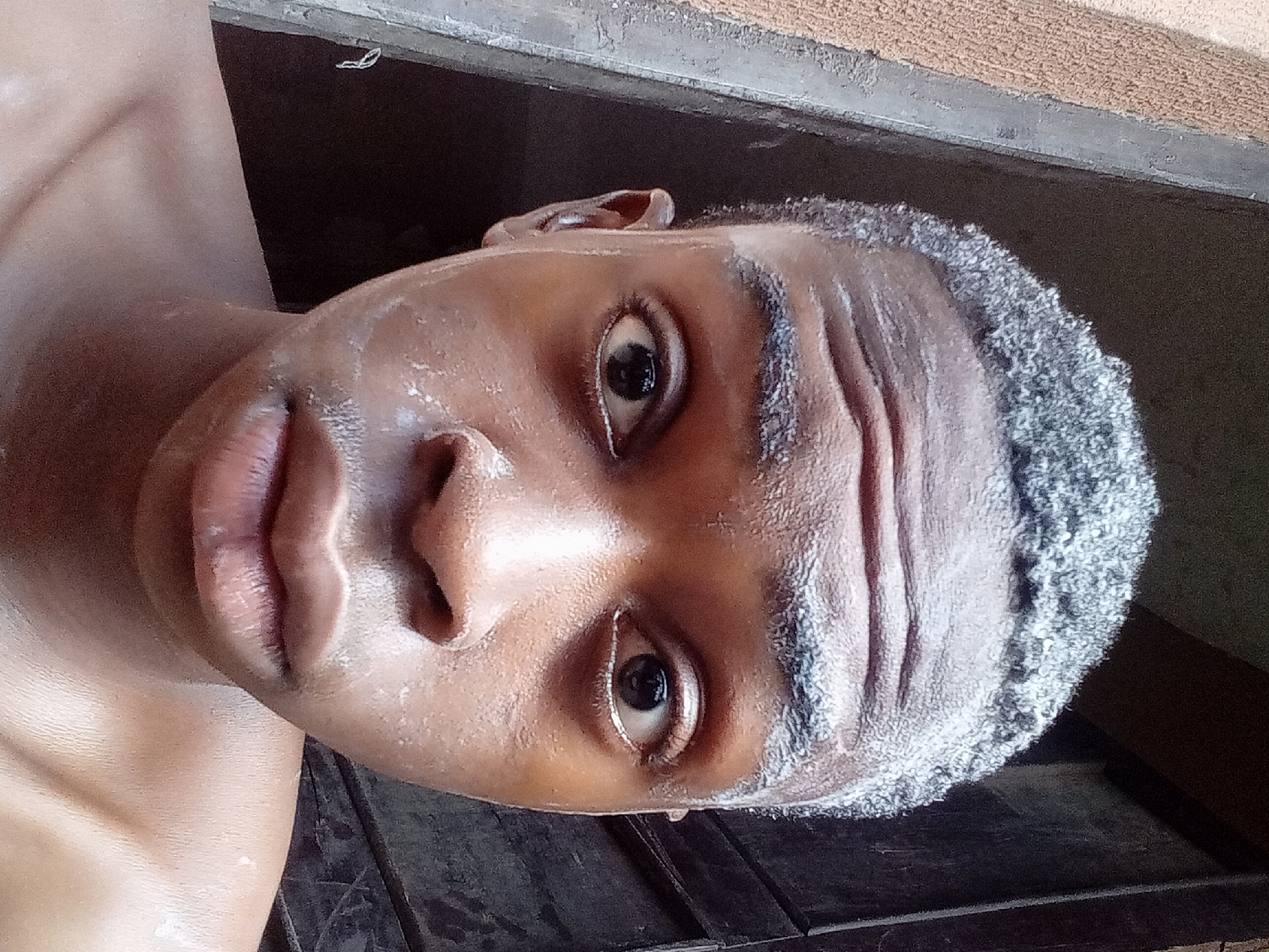 Man applies white cream while grooming in Onitsha home