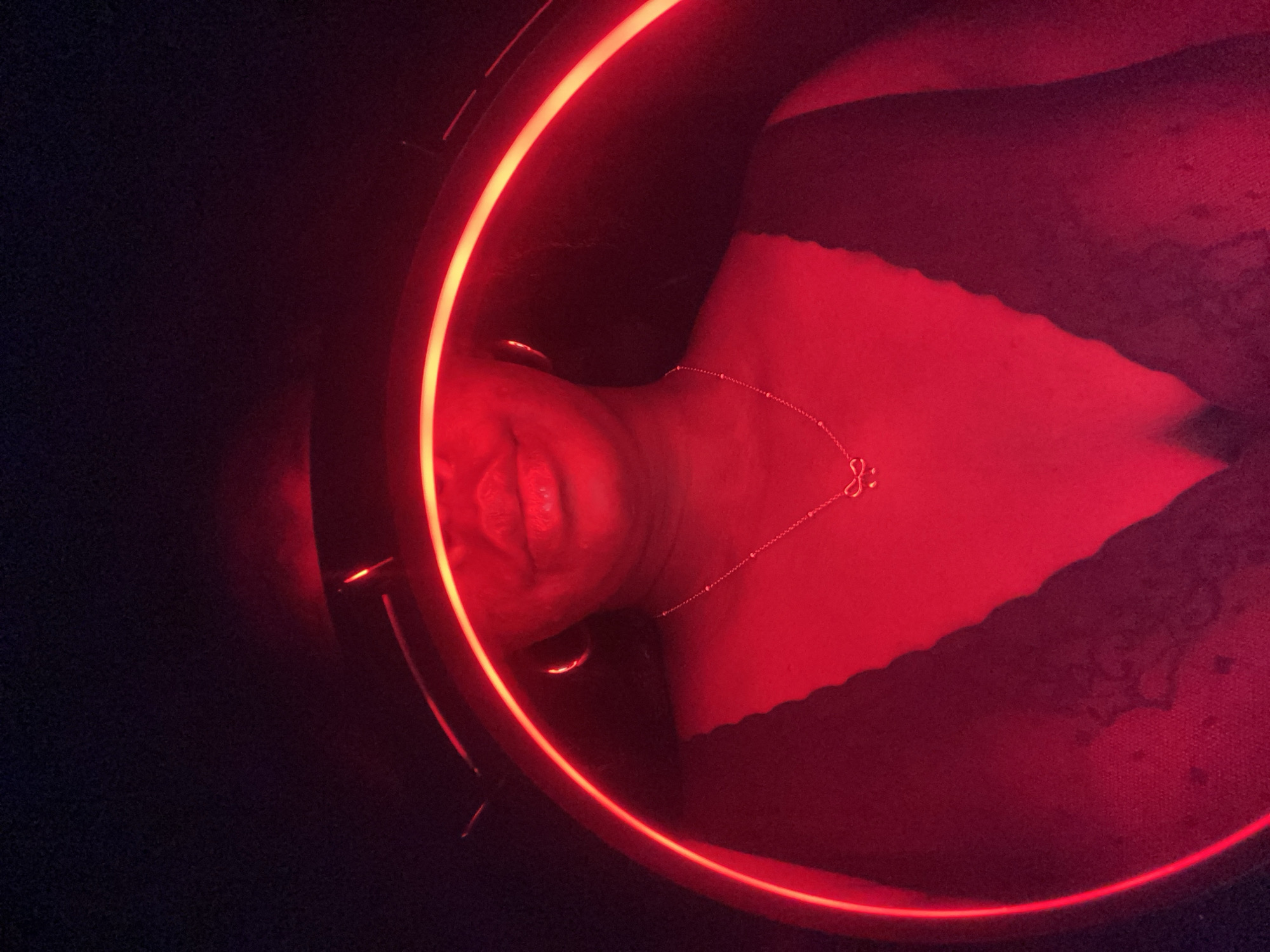 Person photographed under red neon light in Maigizo, Nigeria