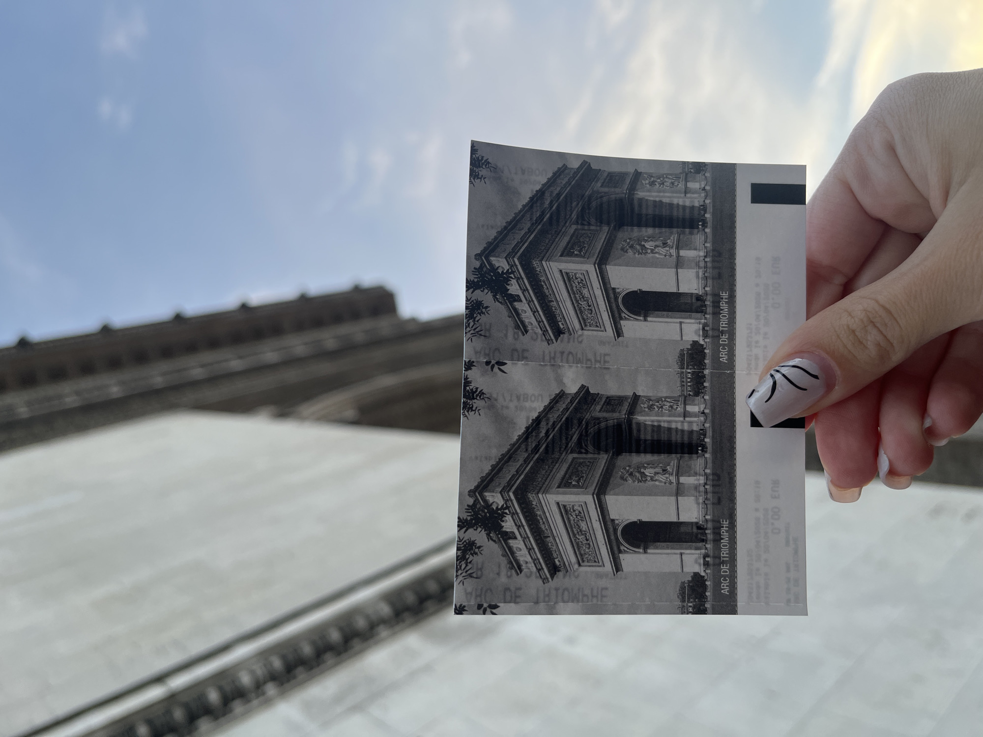Person displays Arc de Triomphe tickets in Paris