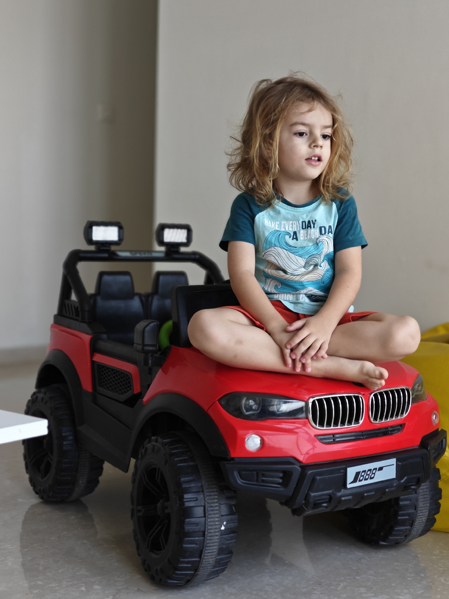 Child plays with red toy car in Mumbai