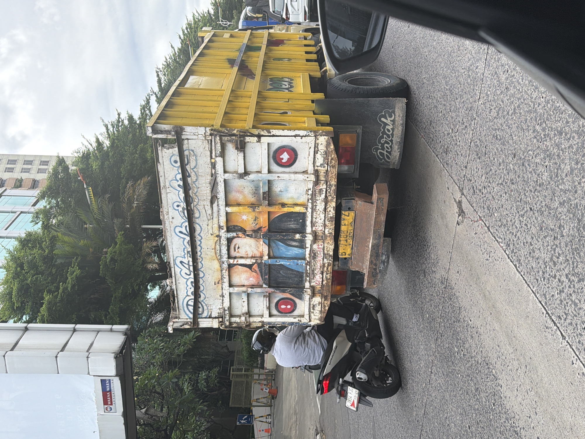 Painted truck spotted with motorcyclist in West Jakarta morning traffic