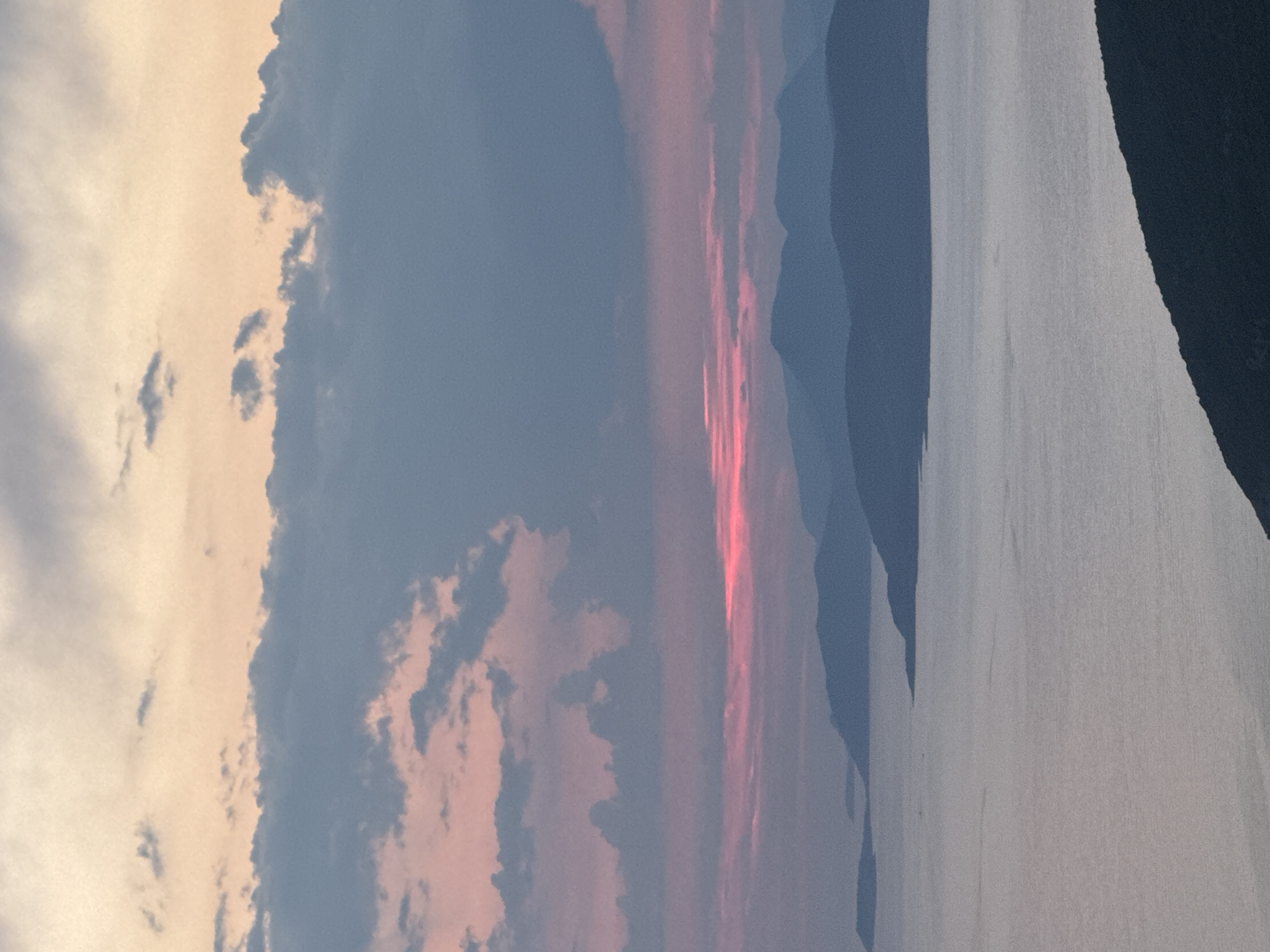 Sunset over Montenegro's coastal waters with mountain backdrop