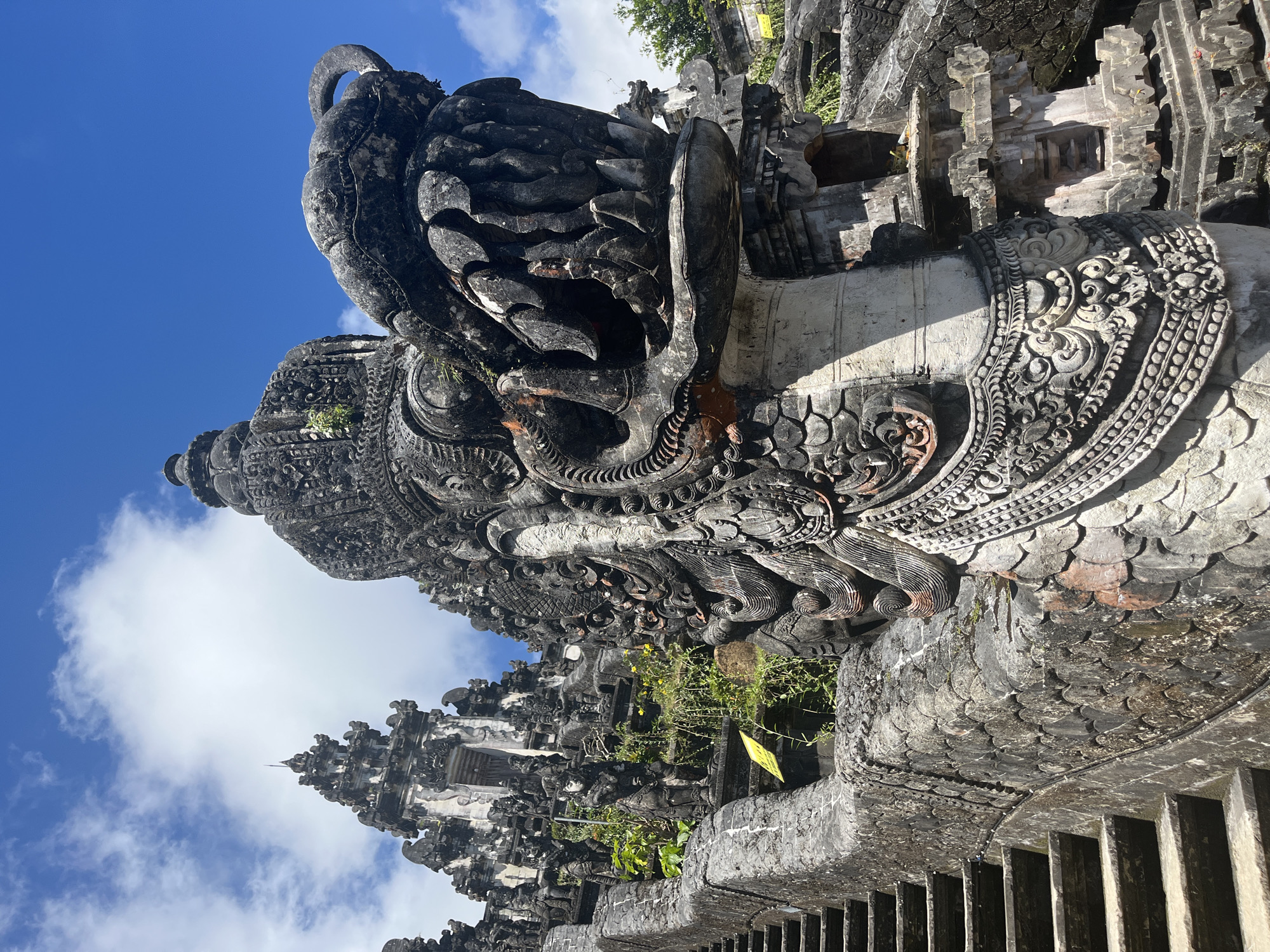 Temple visitor documents ancient Balinese architecture and mountain views