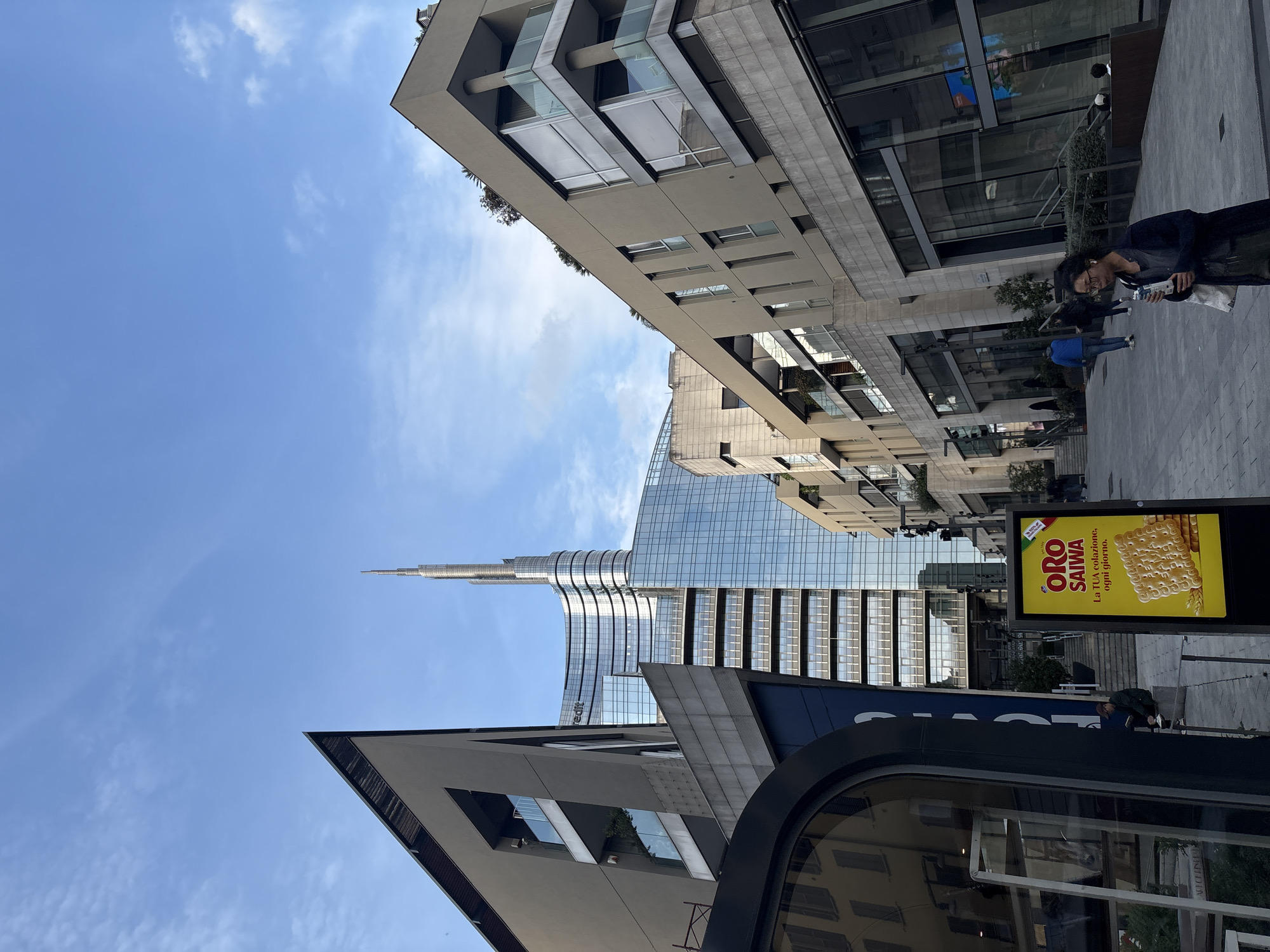 Milan street scene captures Unicredit Tower amid urban landscape