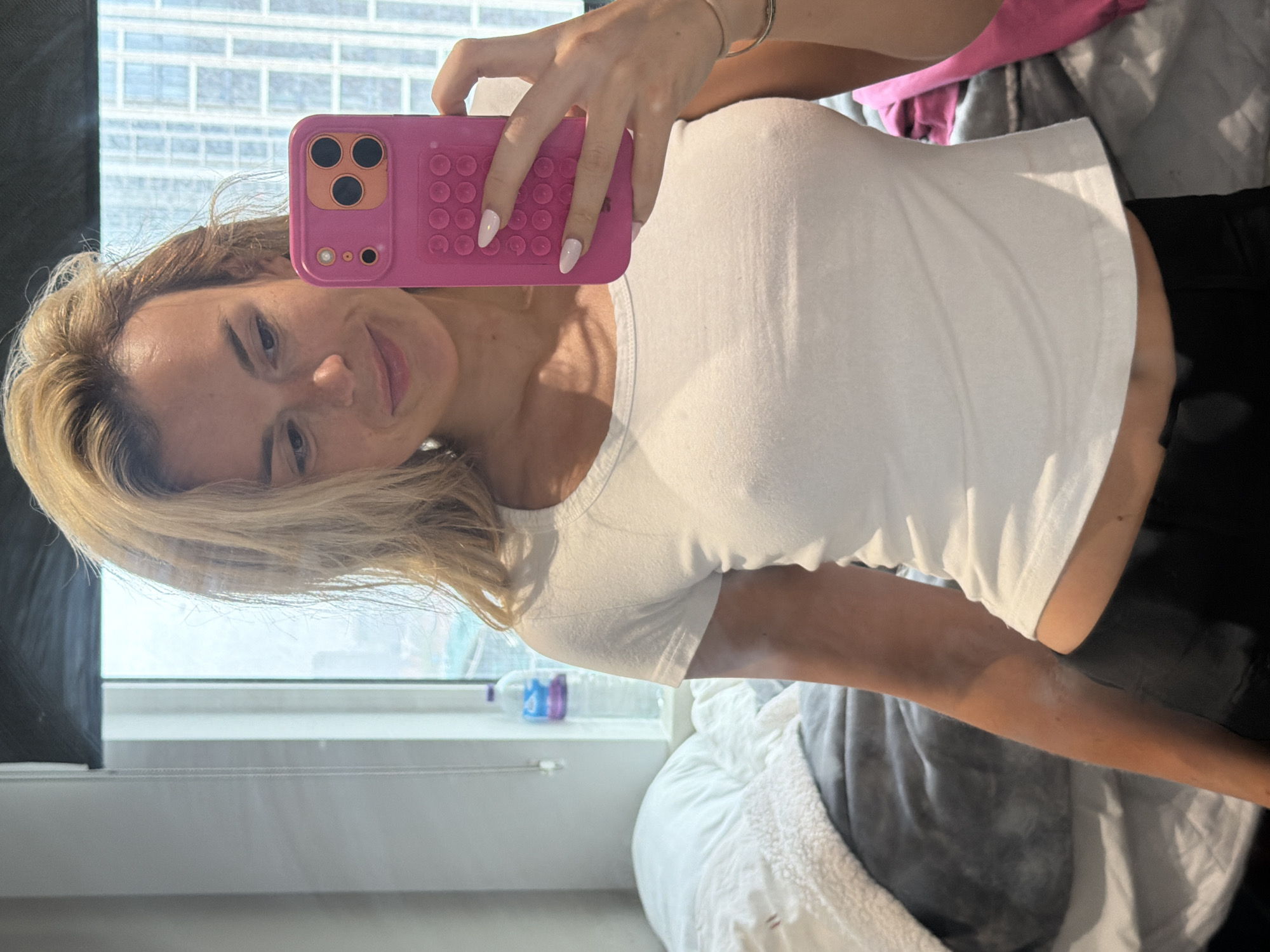 Woman takes bedroom selfies with pink phone in London