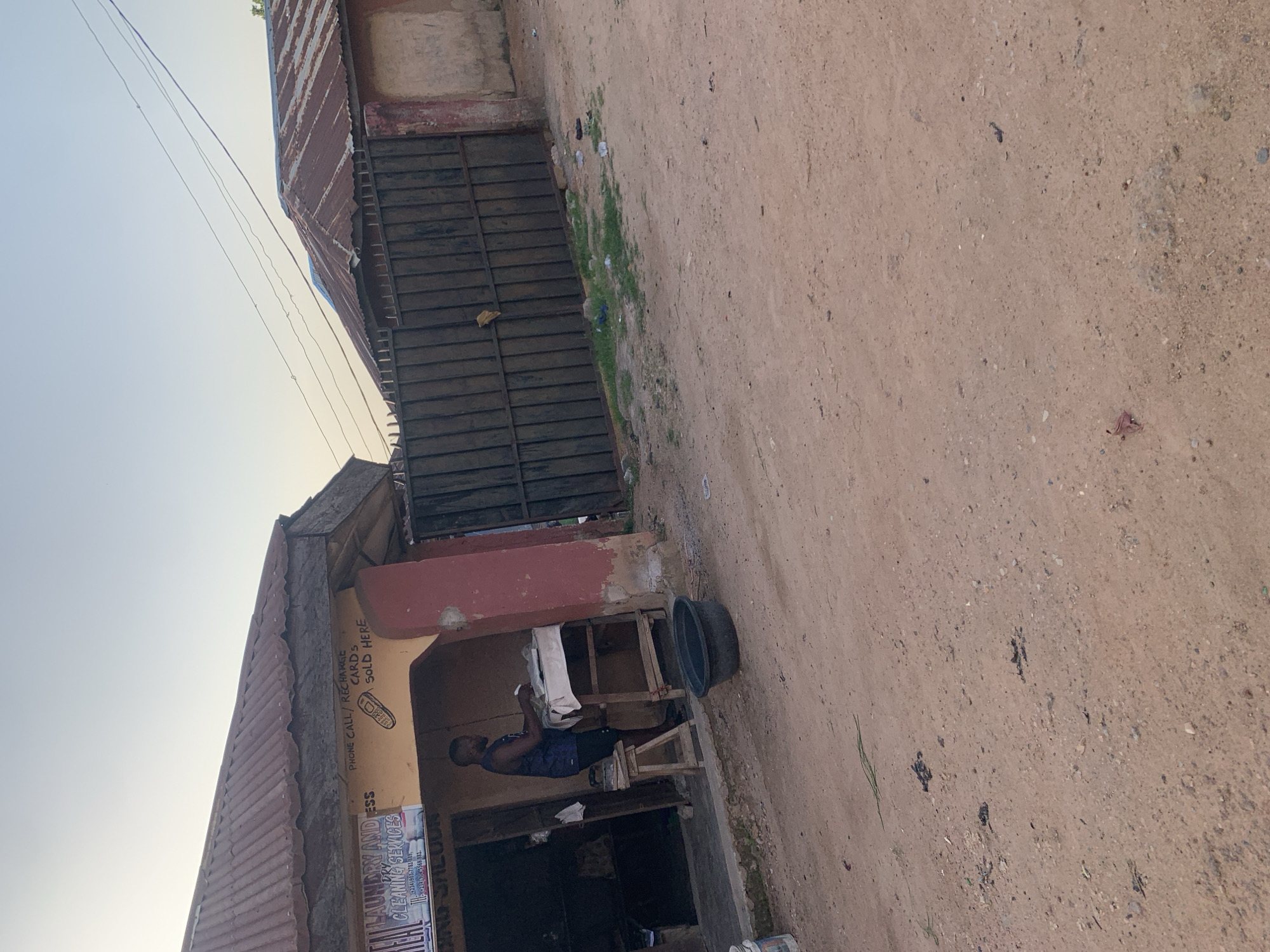 Jalingo street market: clothing stalls, rusted sheds, and afternoon light