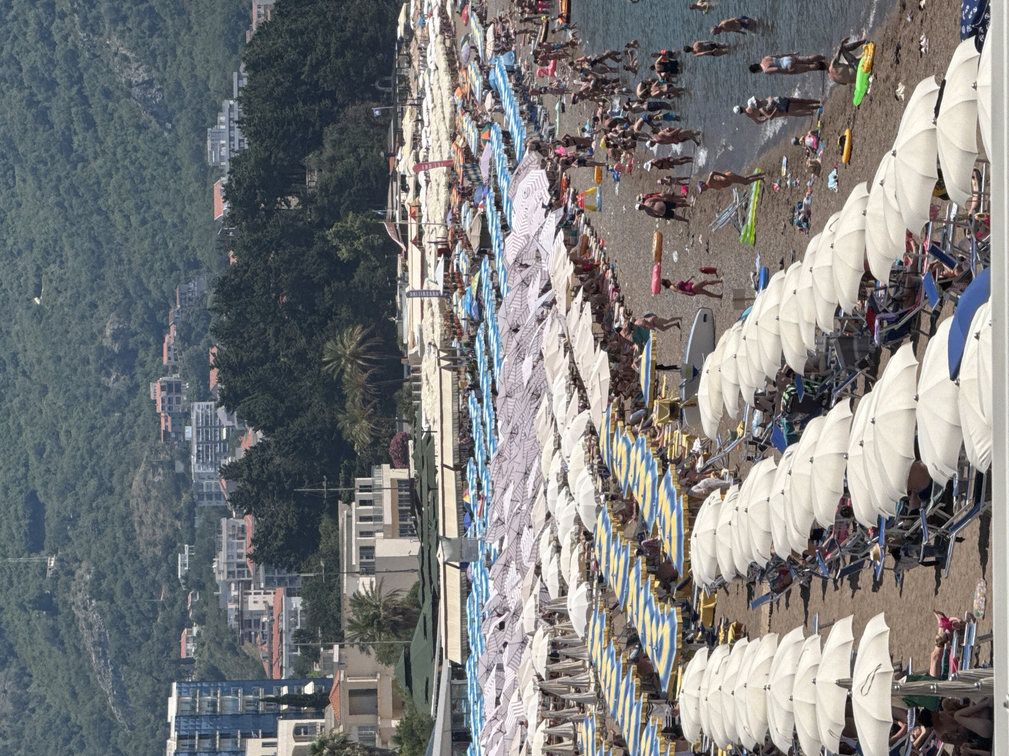 Summer morning on the Budva Riviera — beaches, boats, and paragliders