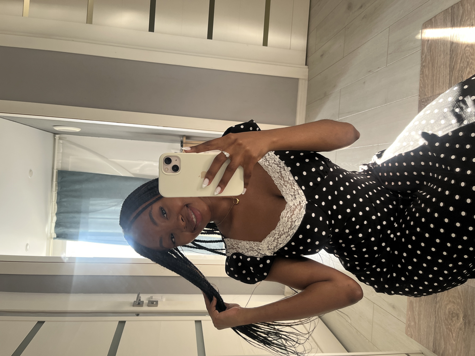 Woman takes selfies in polka dot dress indoors