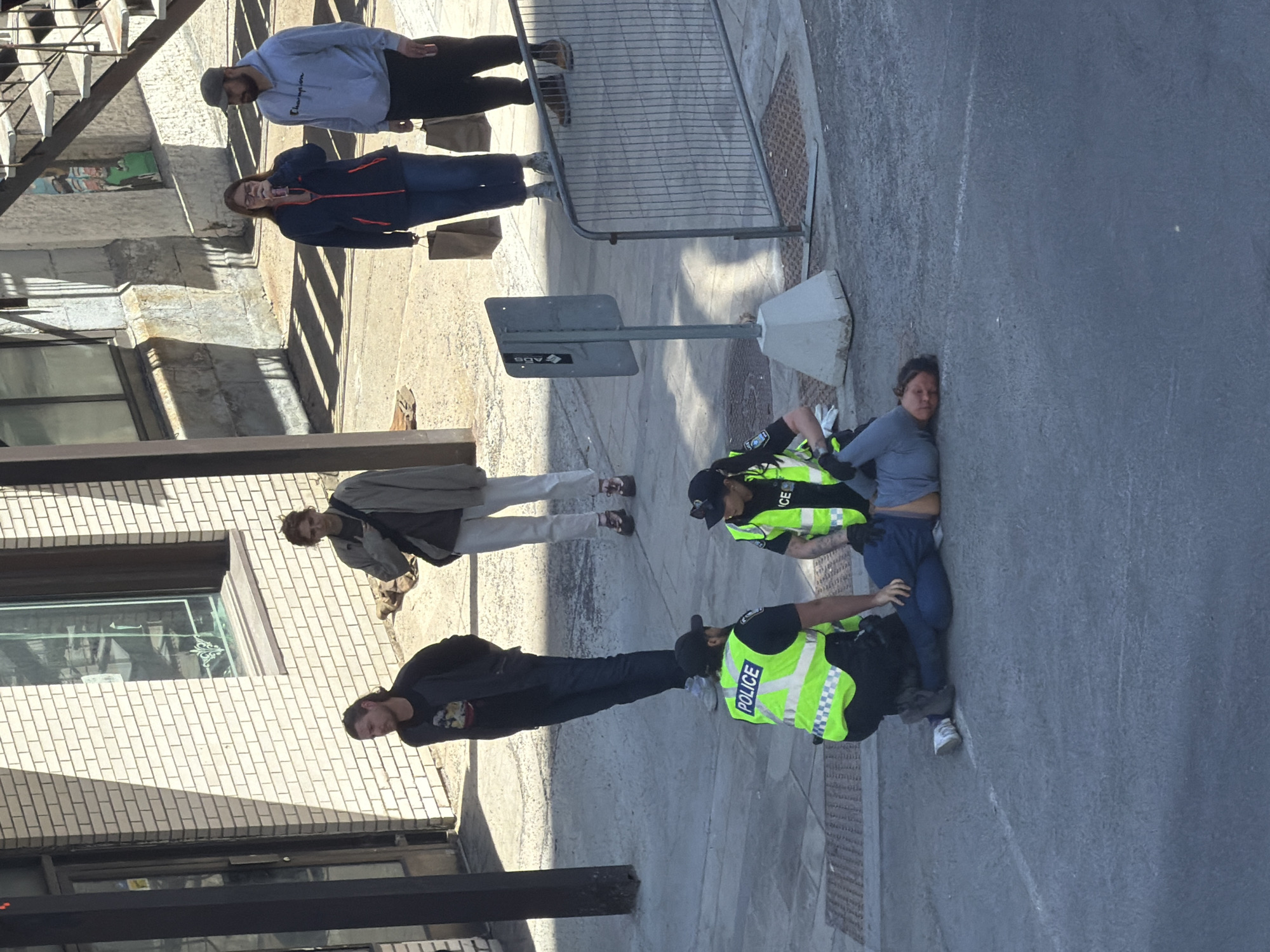 Police officers attend to person on Montreal sidewalk