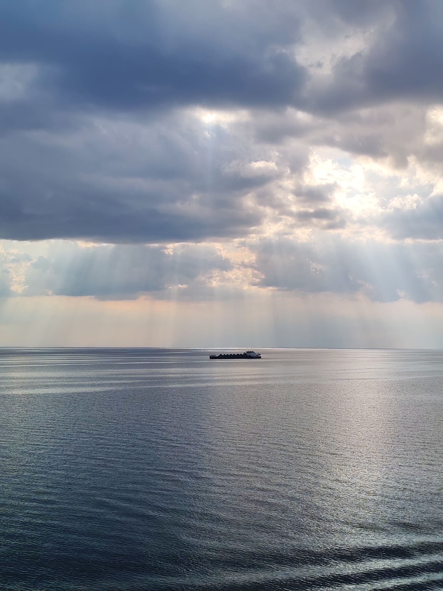 Dramatic sunbeams pierce clouds over Belozersk waterway