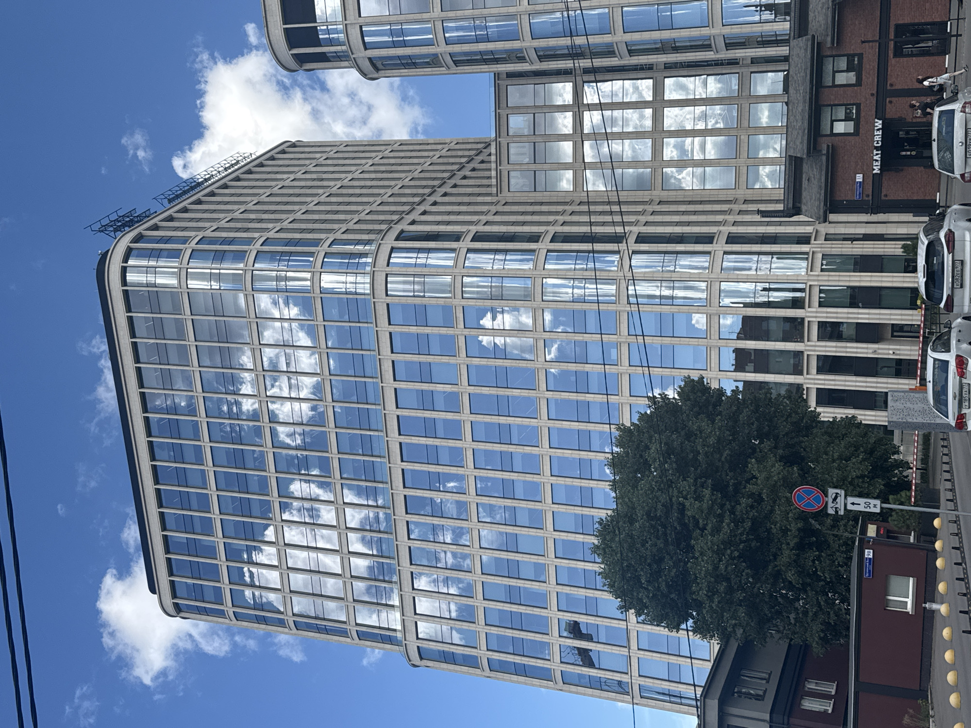 Glass office tower curves against a blue sky