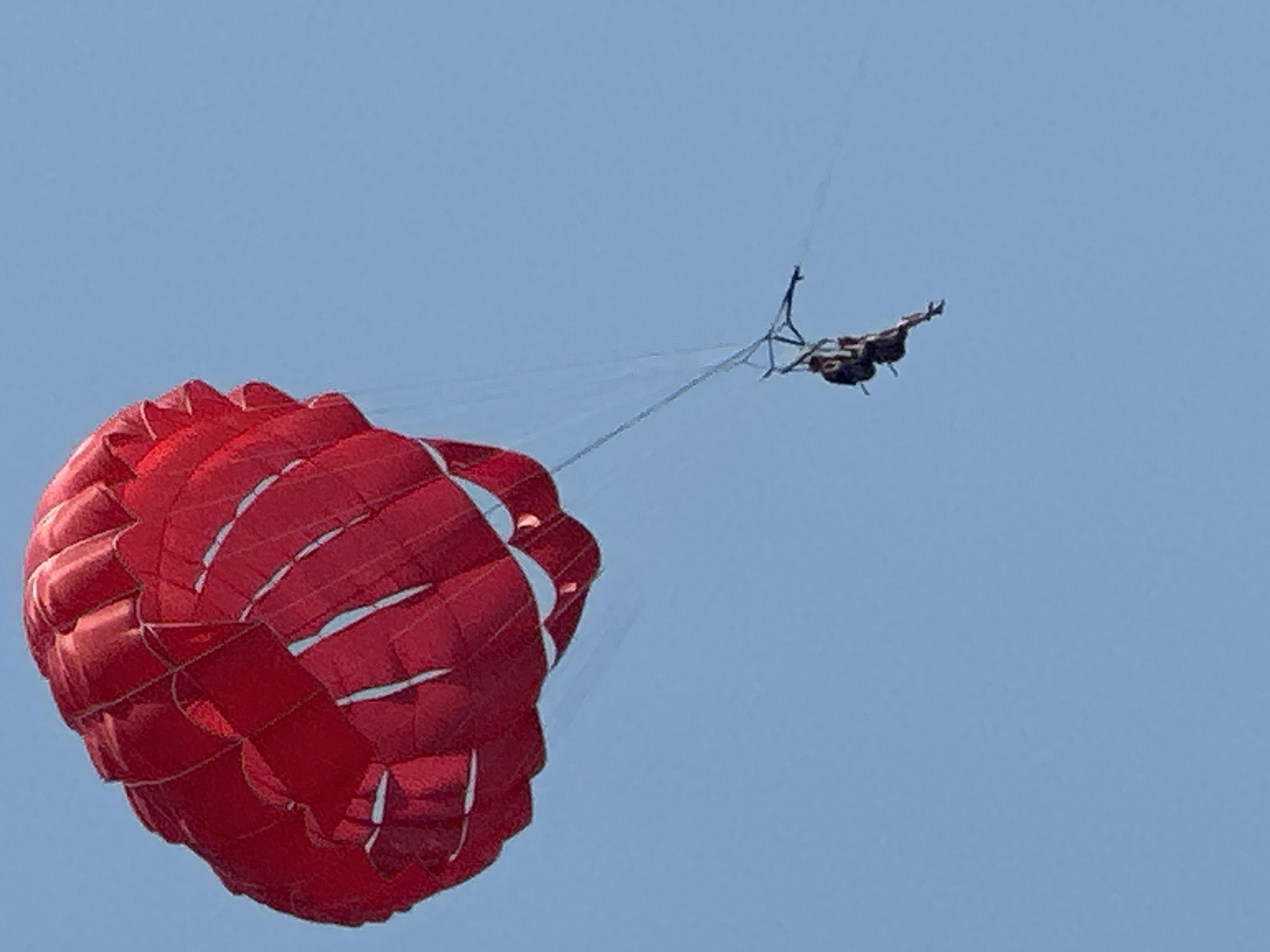 Red parachute deployed over Boreti's clear blue skies
