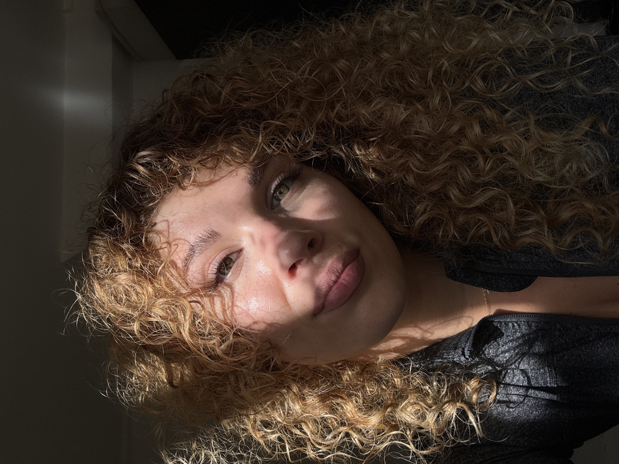 Woman takes selfies in sunlit London room amid plants