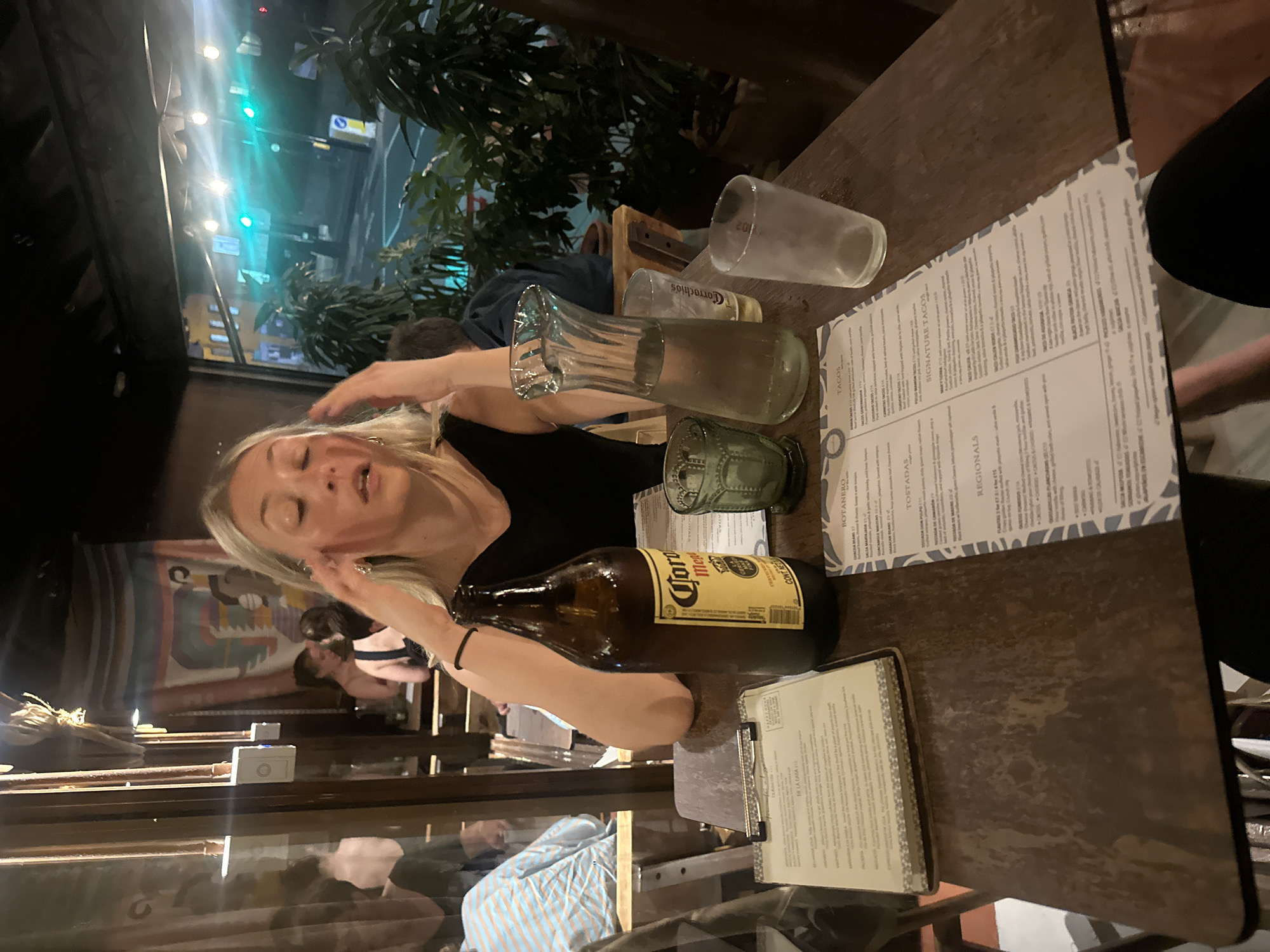 Woman dines with Corona beer at London taco restaurant