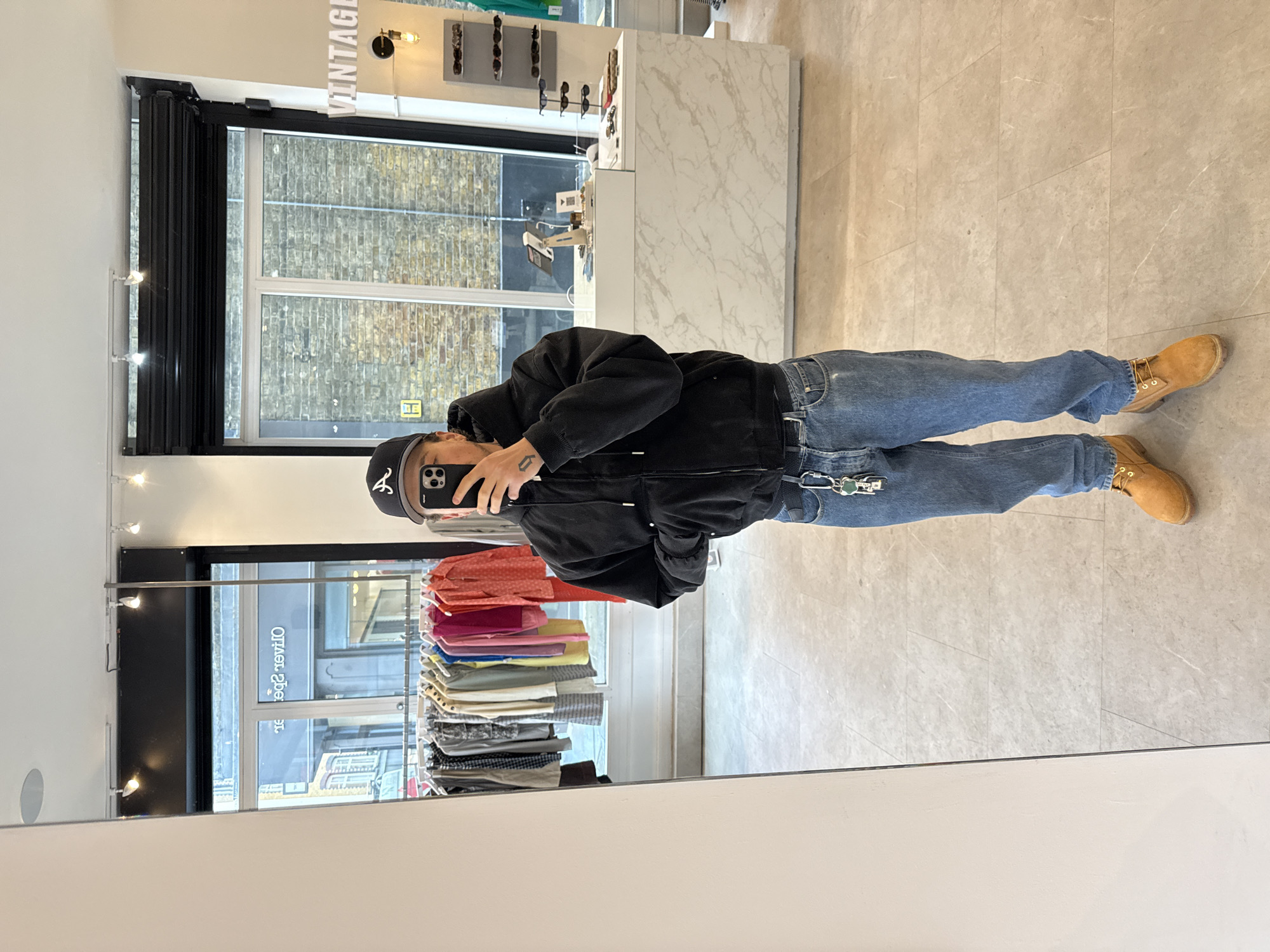 Person takes mirror selfies at London vintage clothing store