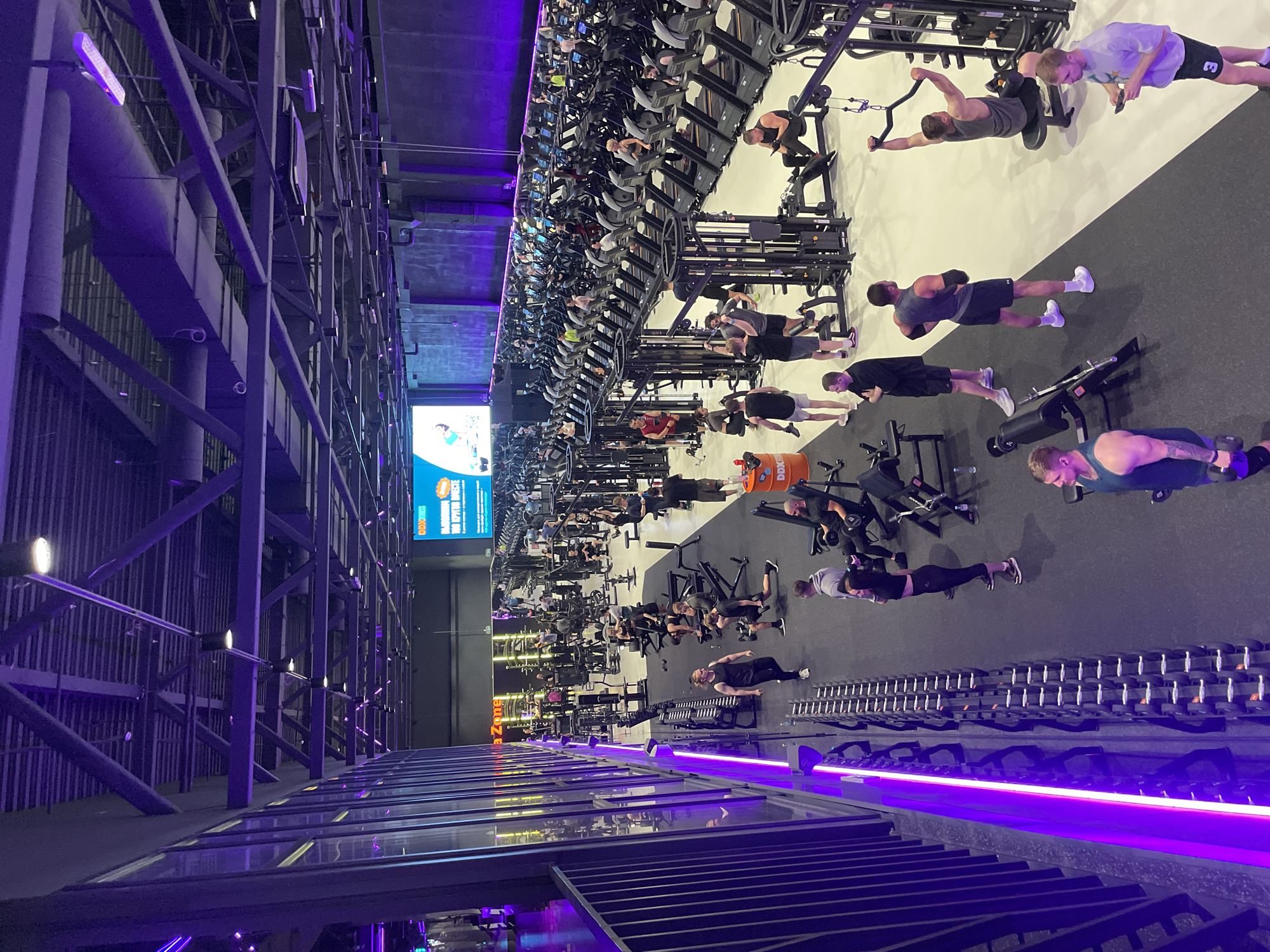 Active evening session inside a sleek, purple-lit gym