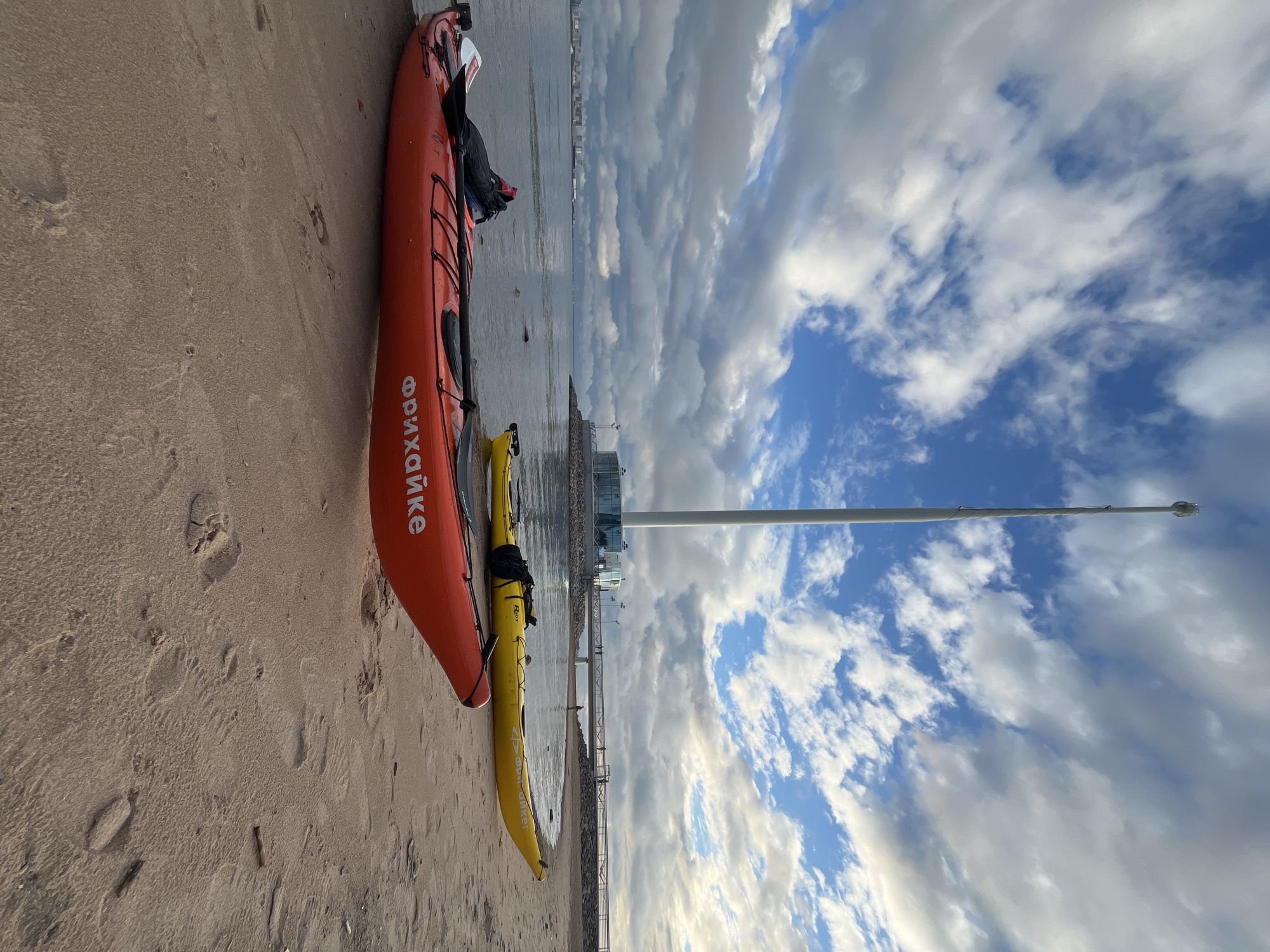 Kayaks on the Neva shore with Saint Petersburg skyline behind