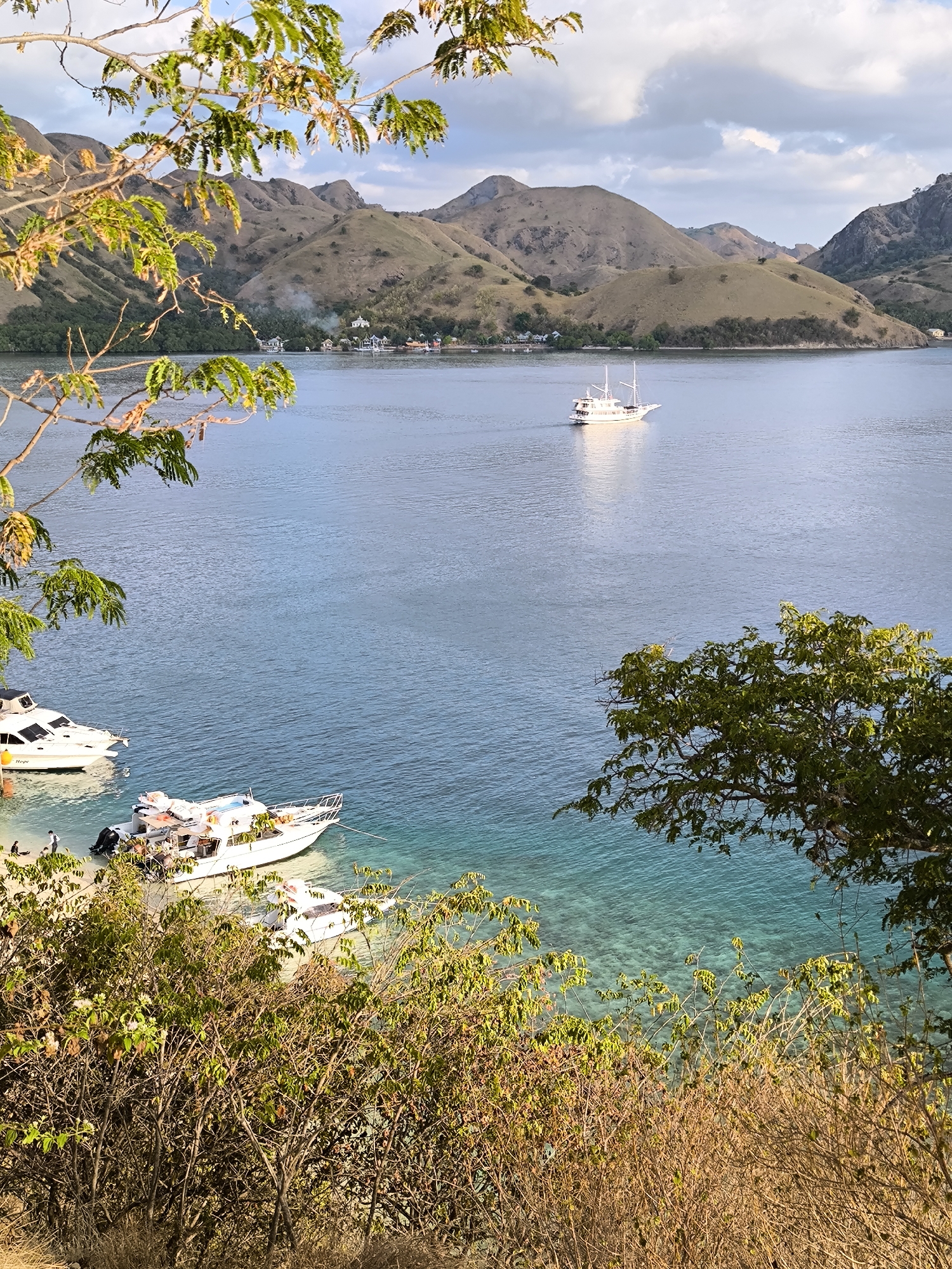 Two-masted sailboat cruises calm Indonesian coastal waters