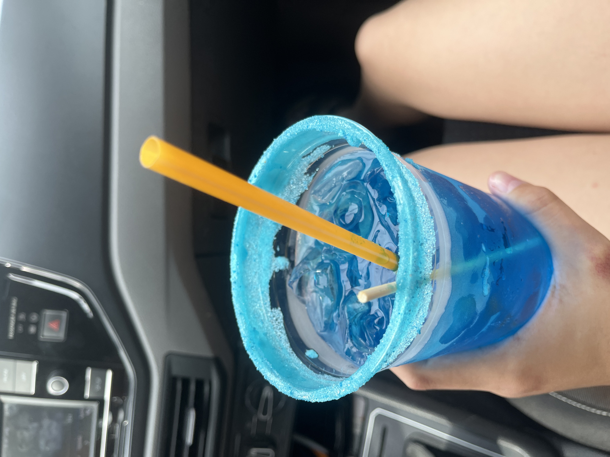 Person enjoys blue beverage in car in Cholula