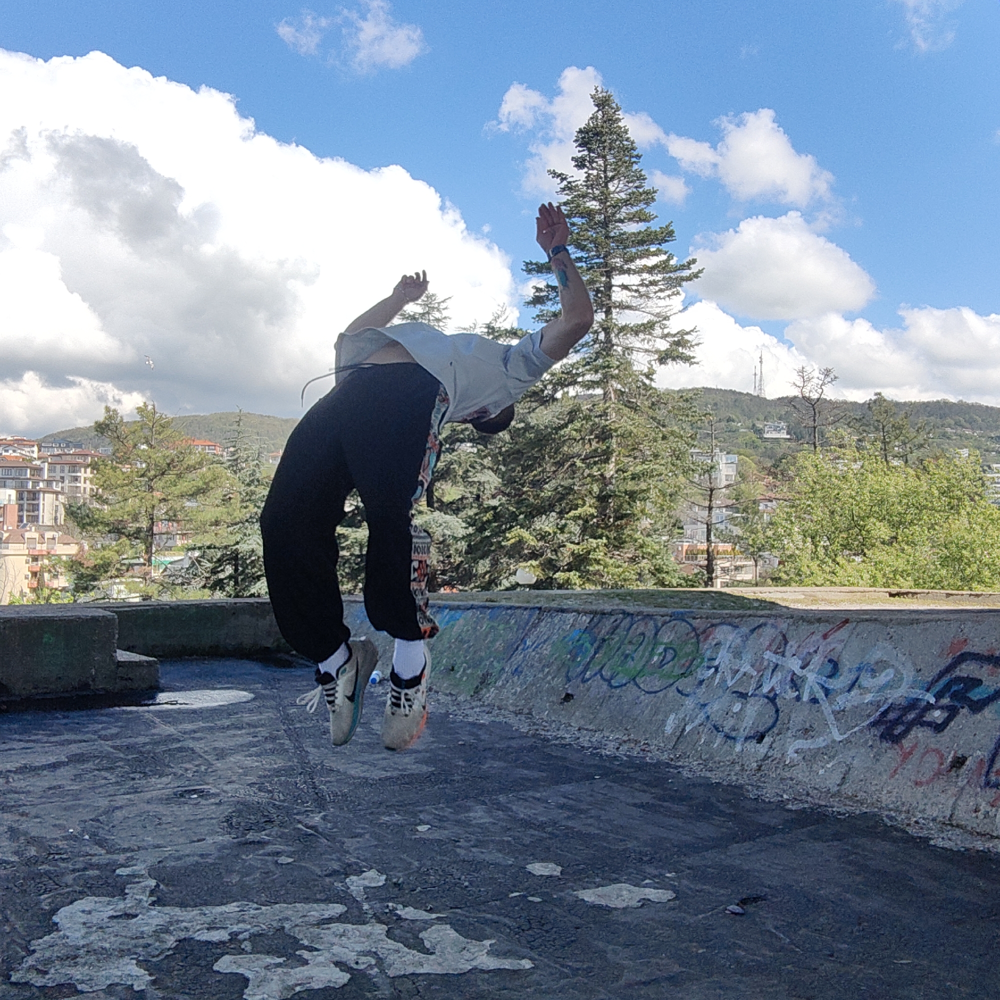 Urban parkour: Person performs backflips near graffitied wall