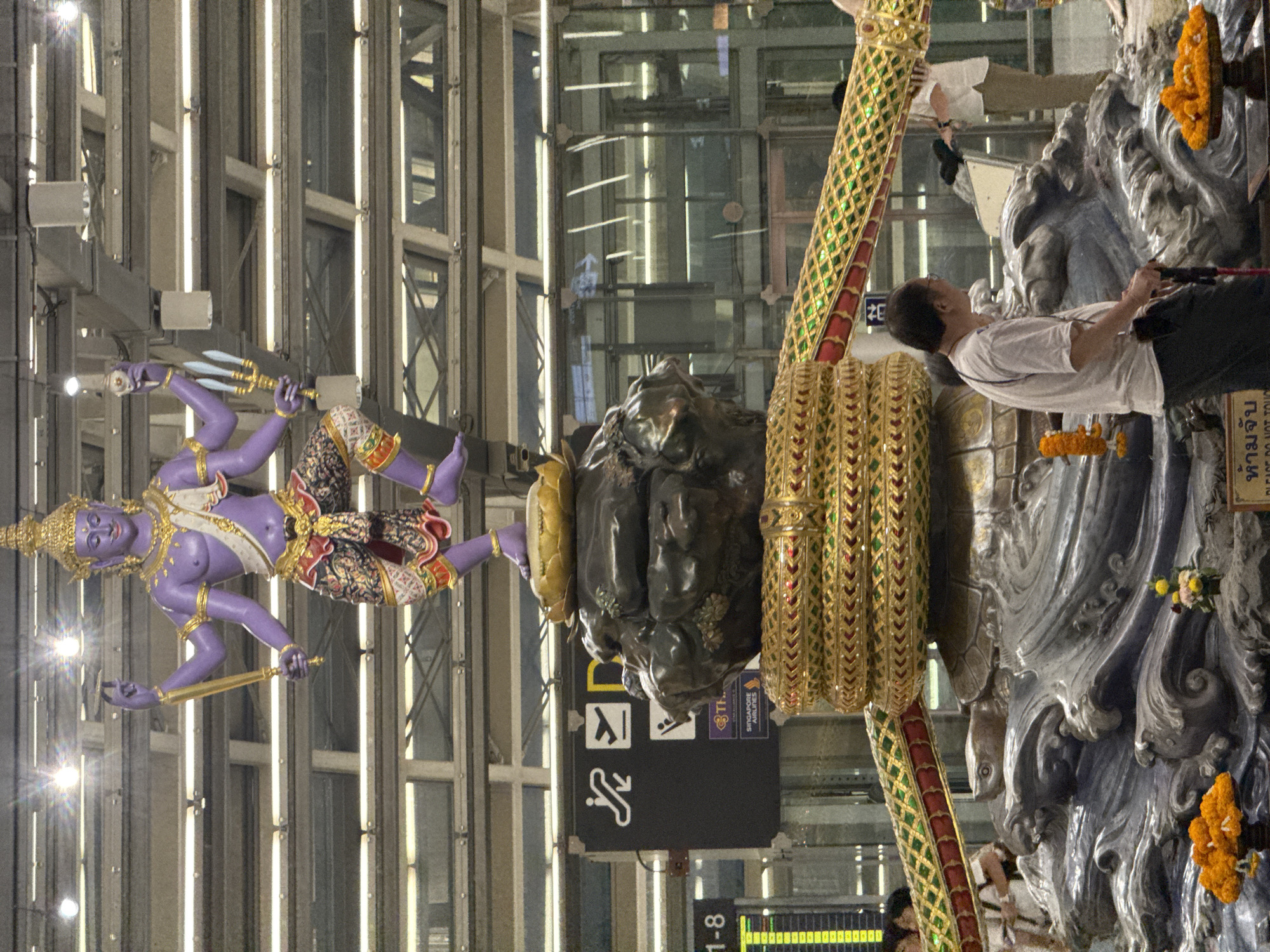 Layover at Suvarnabhumi, with Hindu sculptures and departure boards