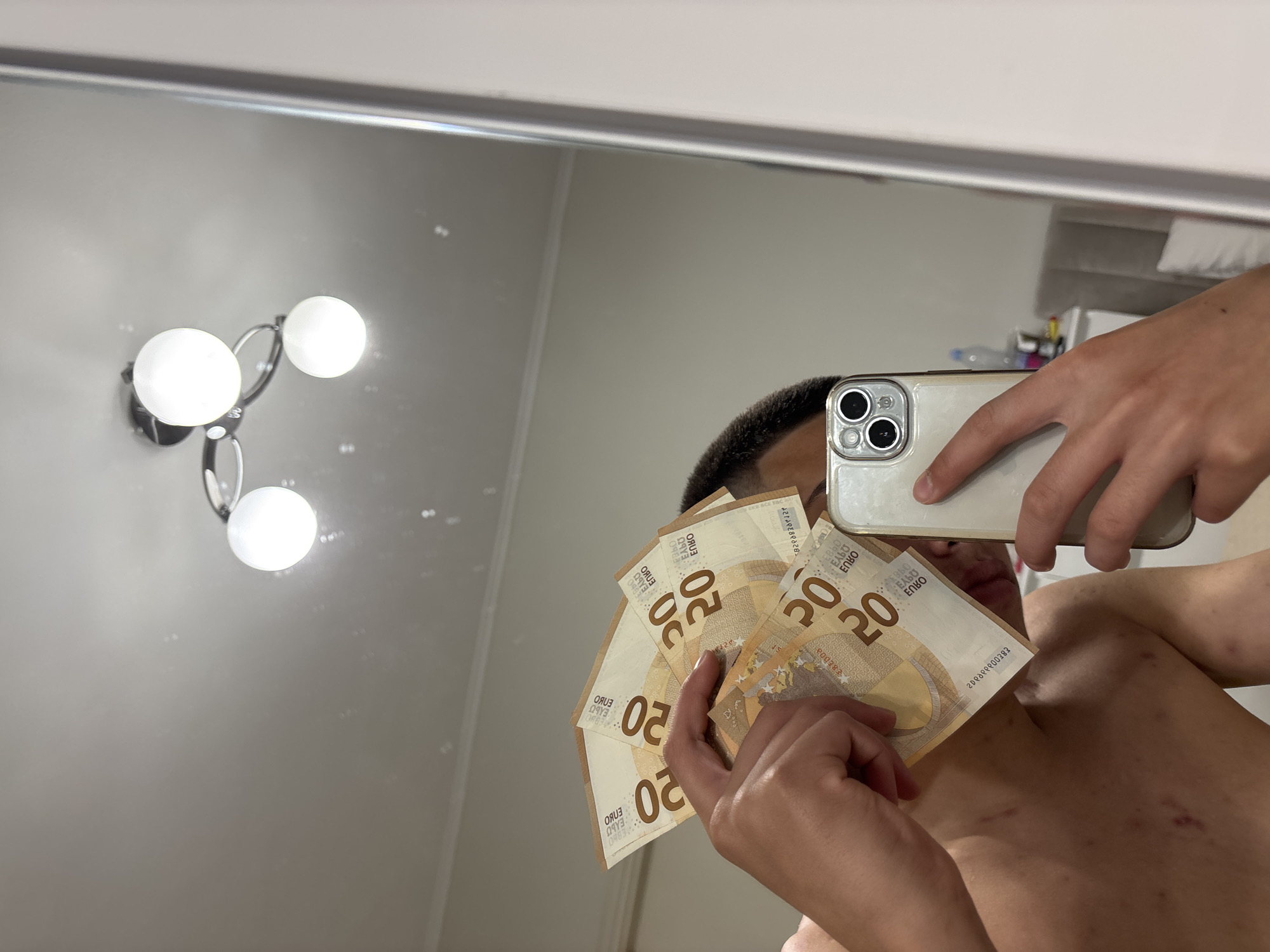 Young man takes mirror selfies with Euro cash in Sofia