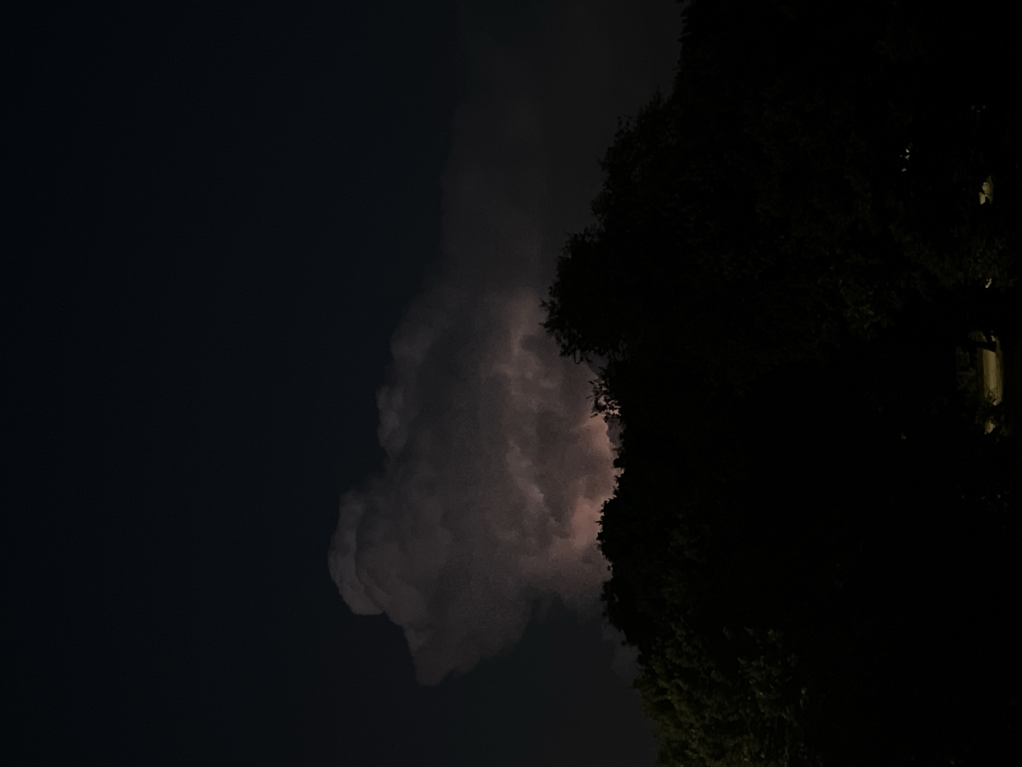 Storm cloud glows over Milan's night skyline
