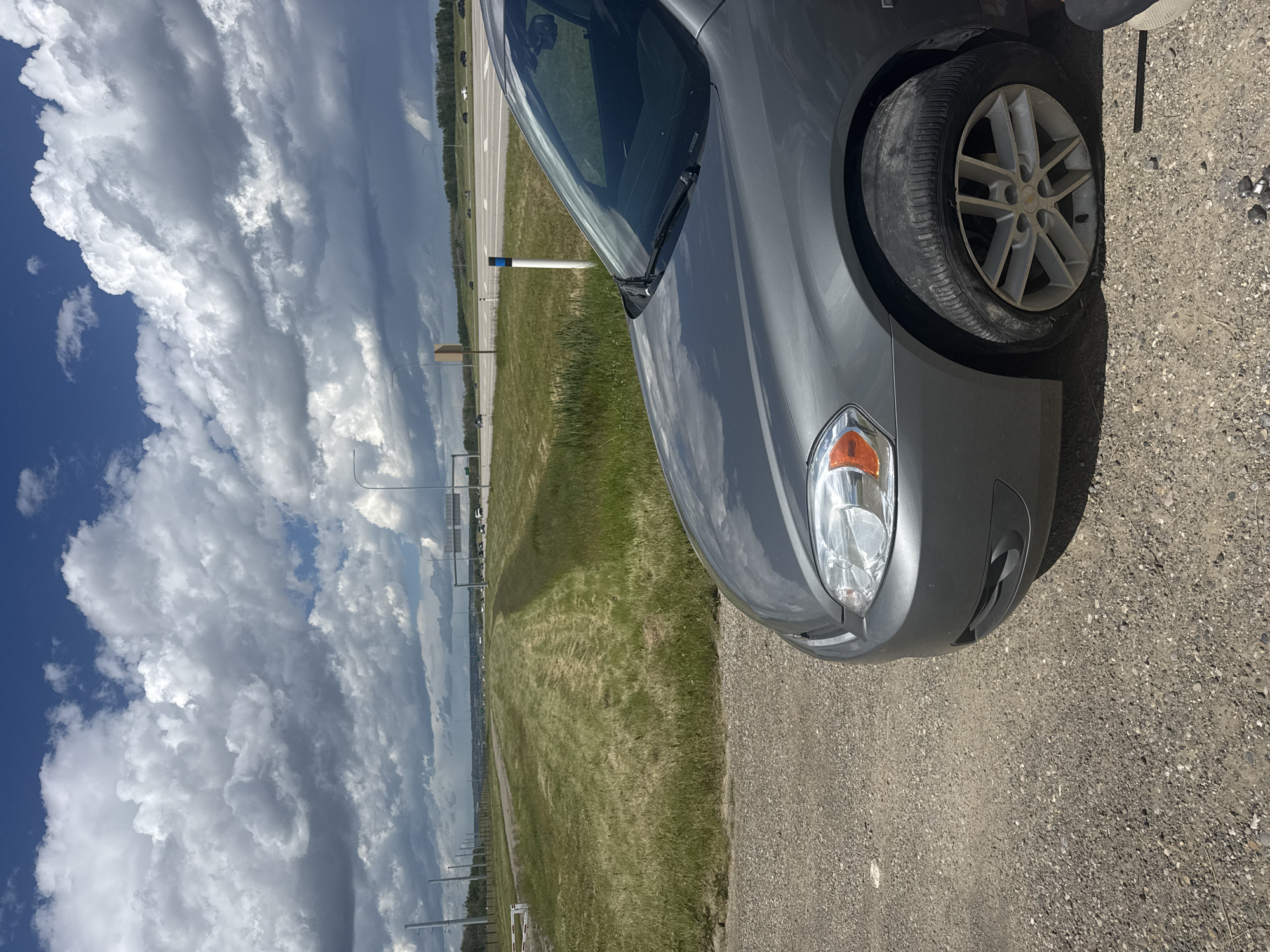 Grey sedan pulled over on Calgary highway with flat tire