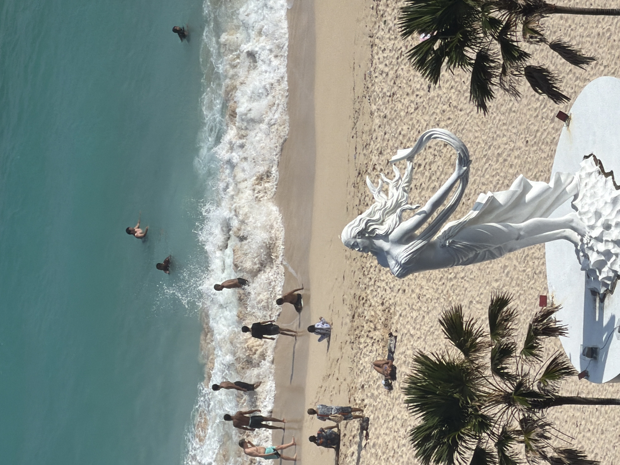 Tourists capture scenic Bali coastal views and statues