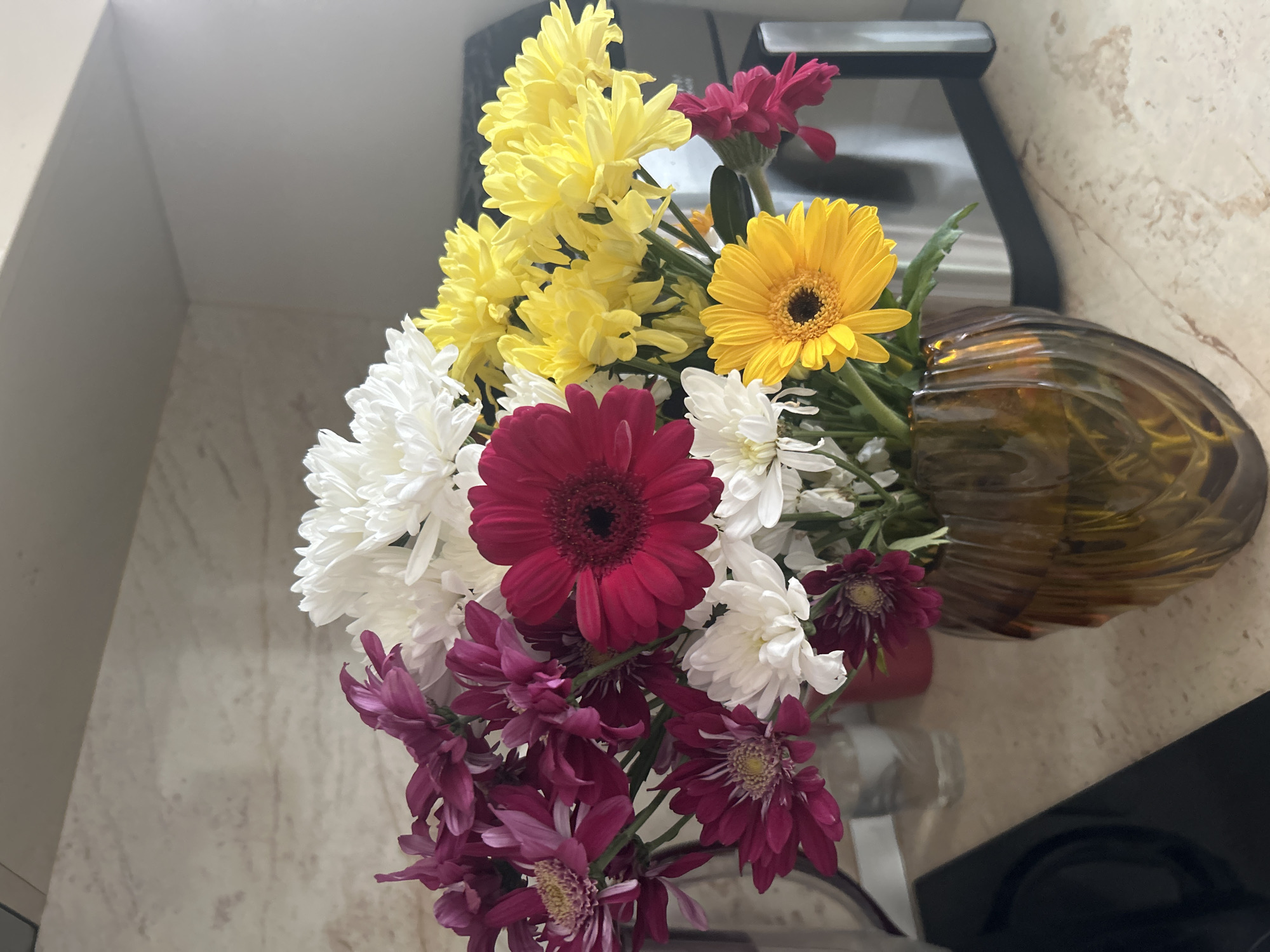 Mixed flower bouquet displayed in amber vase