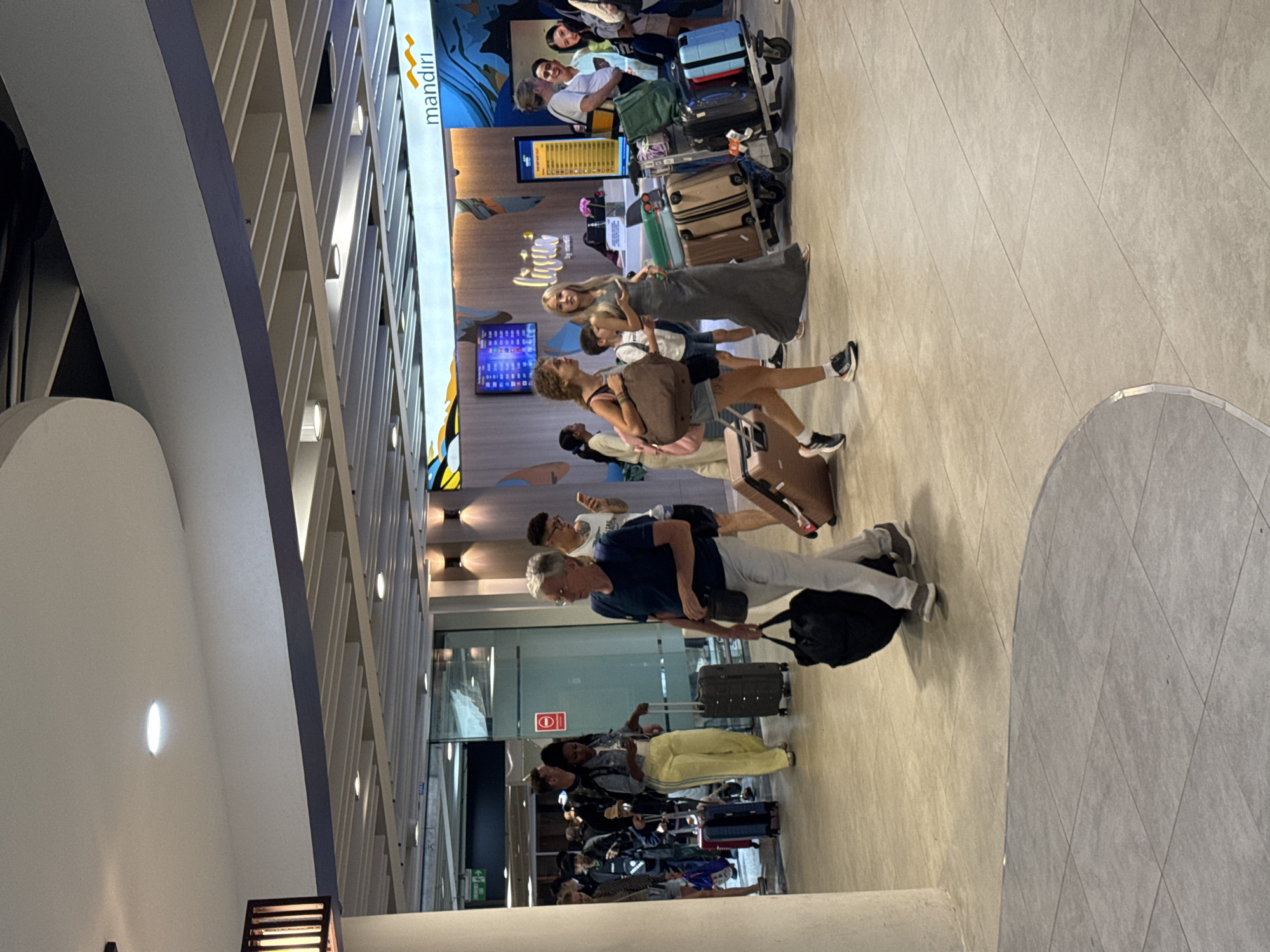 Busy afternoon foot traffic through Bali's Ngurah Rai Airport terminal