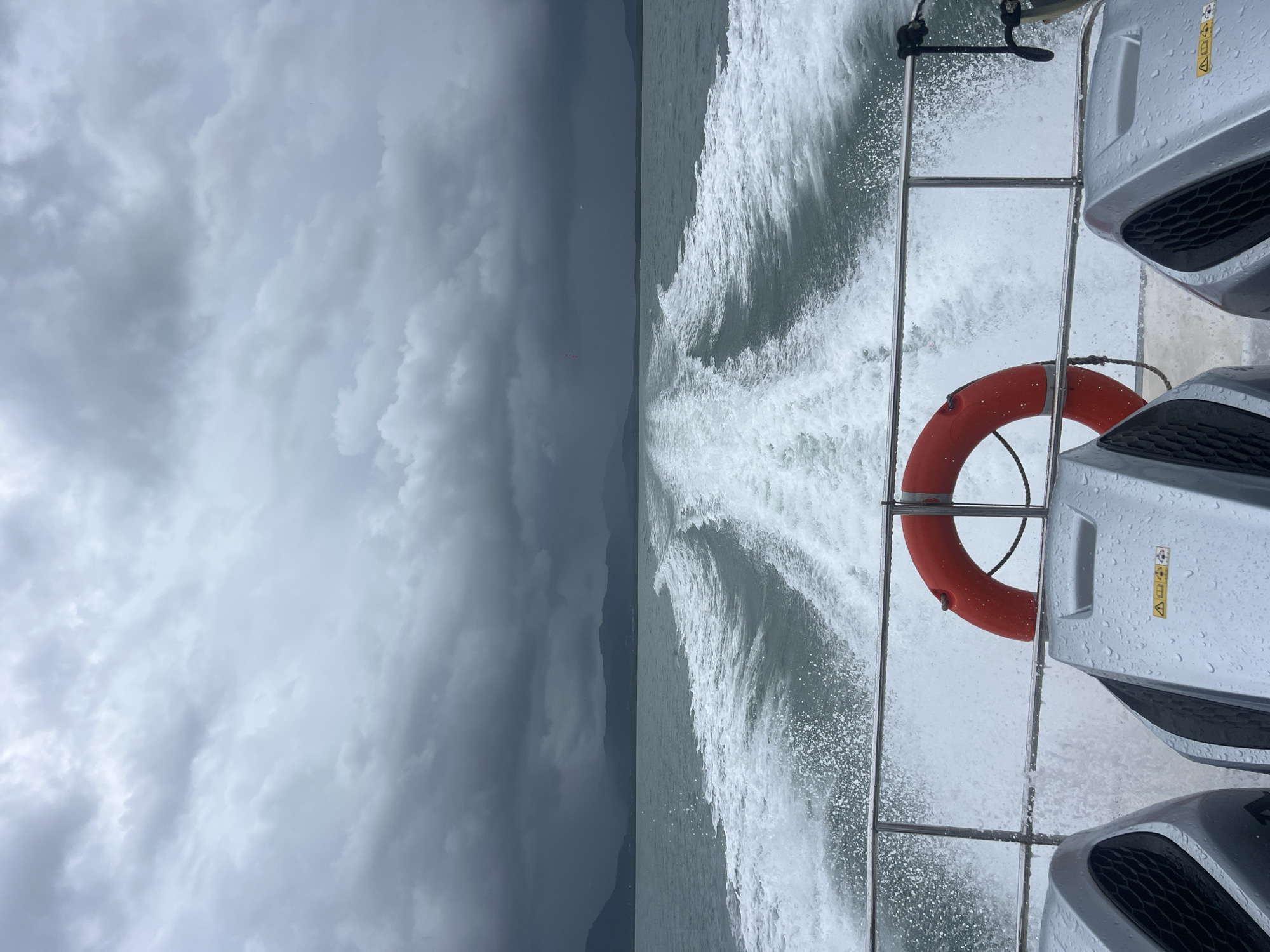 Twin outboard motors pushing through rough Thai coastal waters