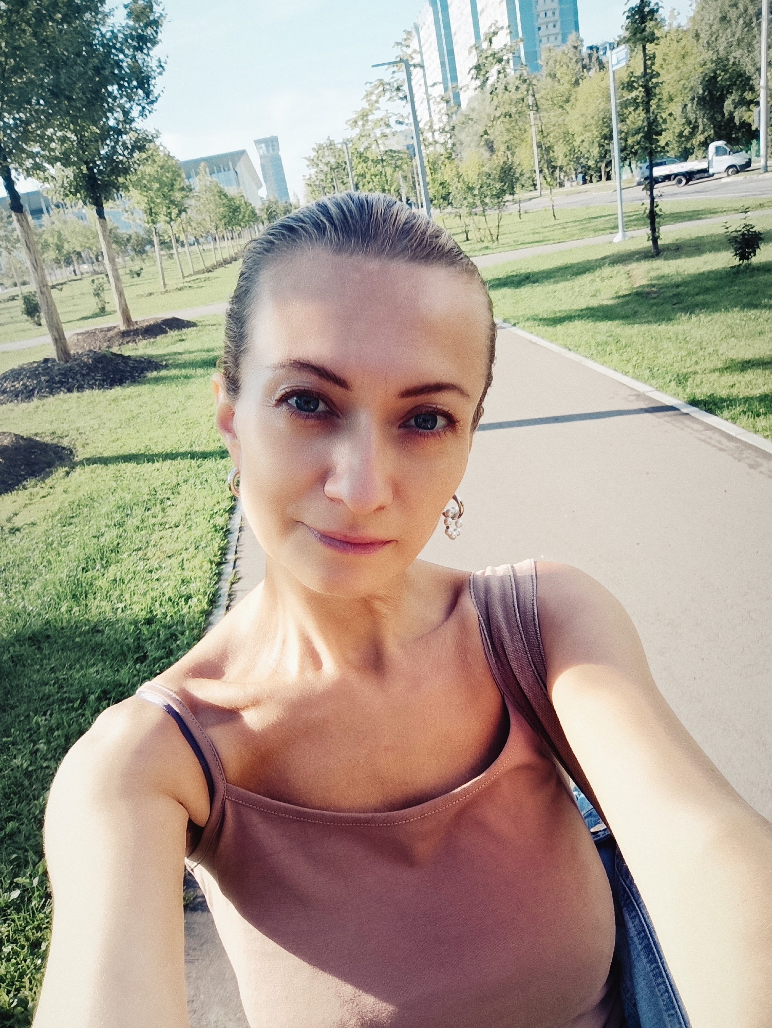 Selfie on a Moscow path with greenery and city backdrop