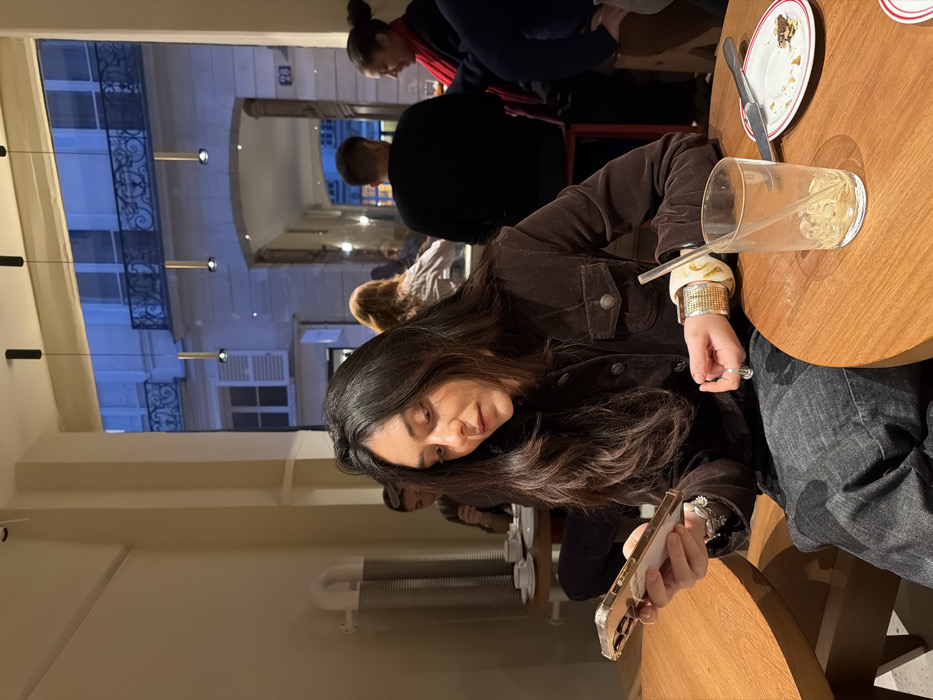 Woman uses smartphone at Paris cafe table