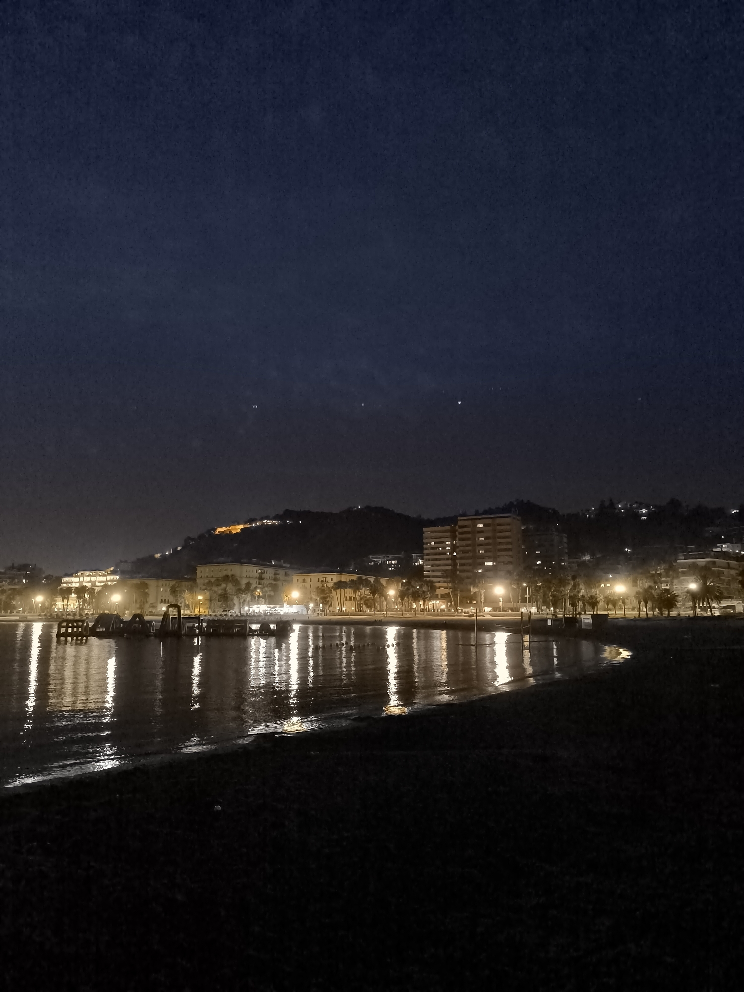 Night views of a southern European coastal city from two angles.