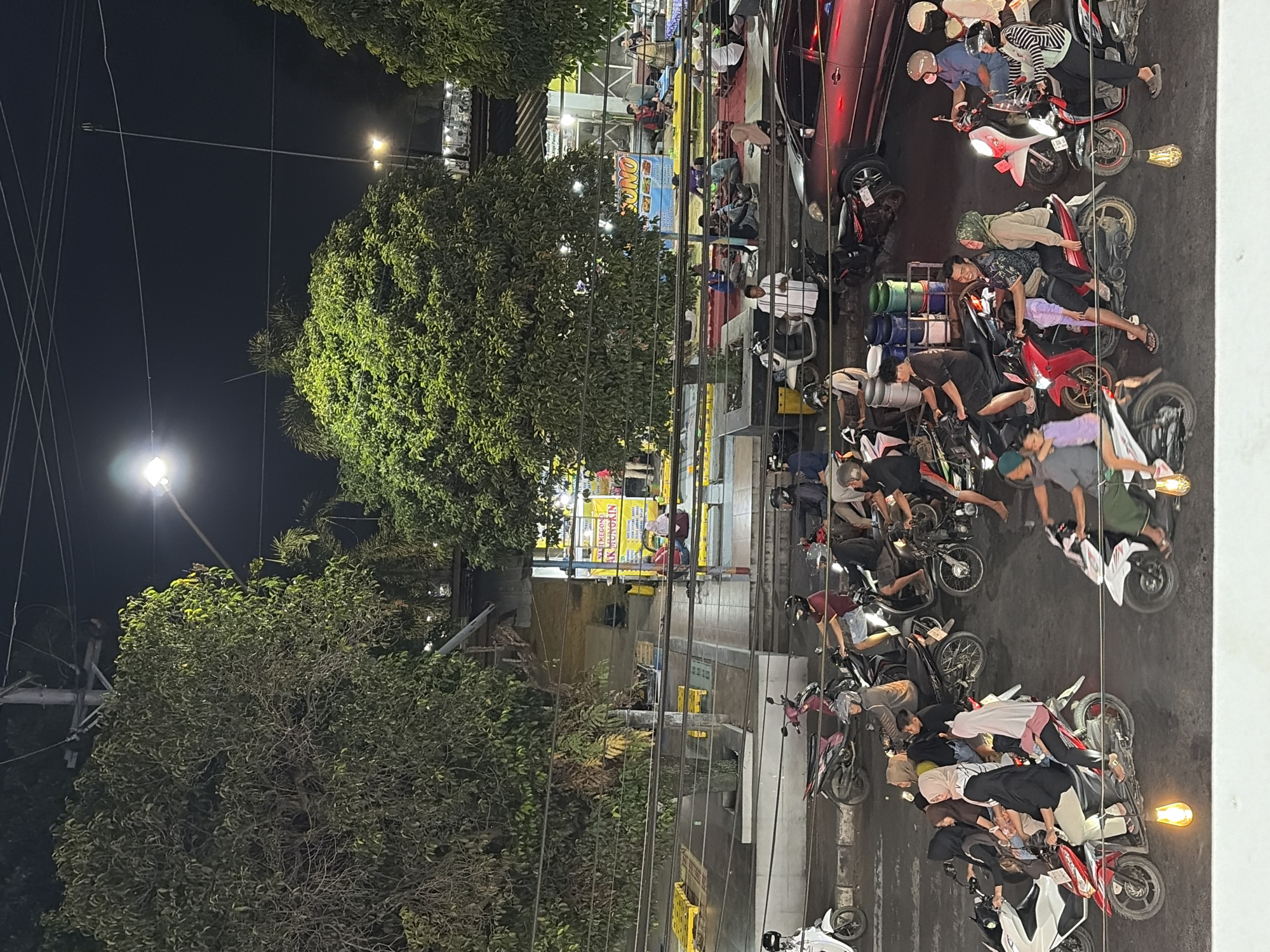 Batang intersection at night, motorbikes and a cycling LED sign