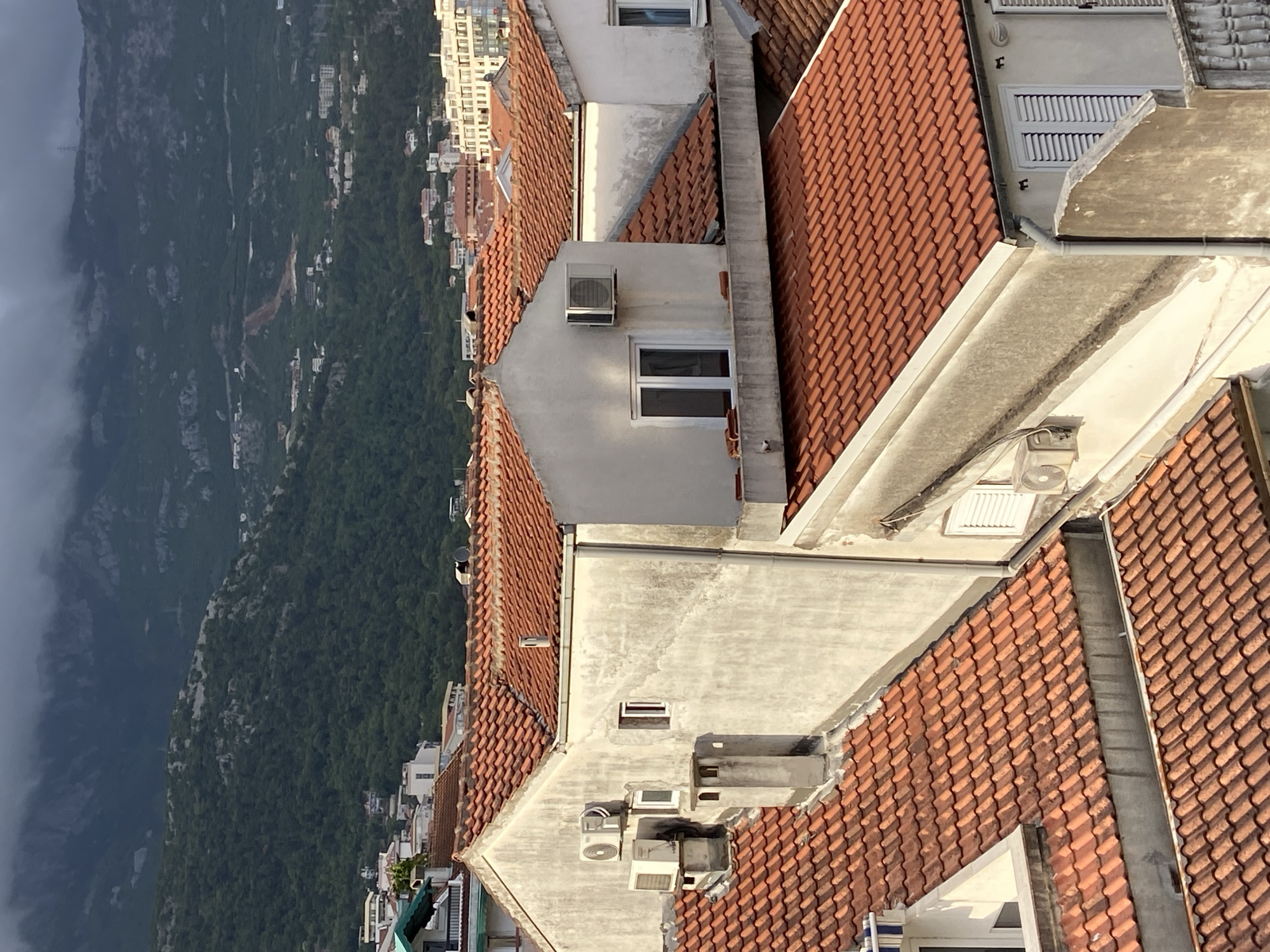 Aerial views document Budva's urban landscape under cloudy skies