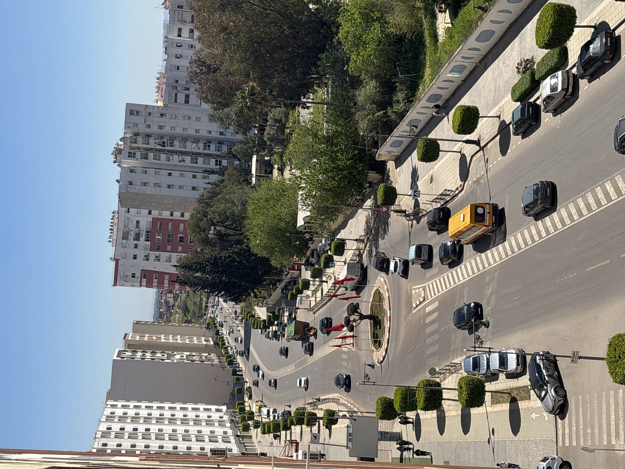Traffic flows through Meknes roundabout with maintenance vehicle present