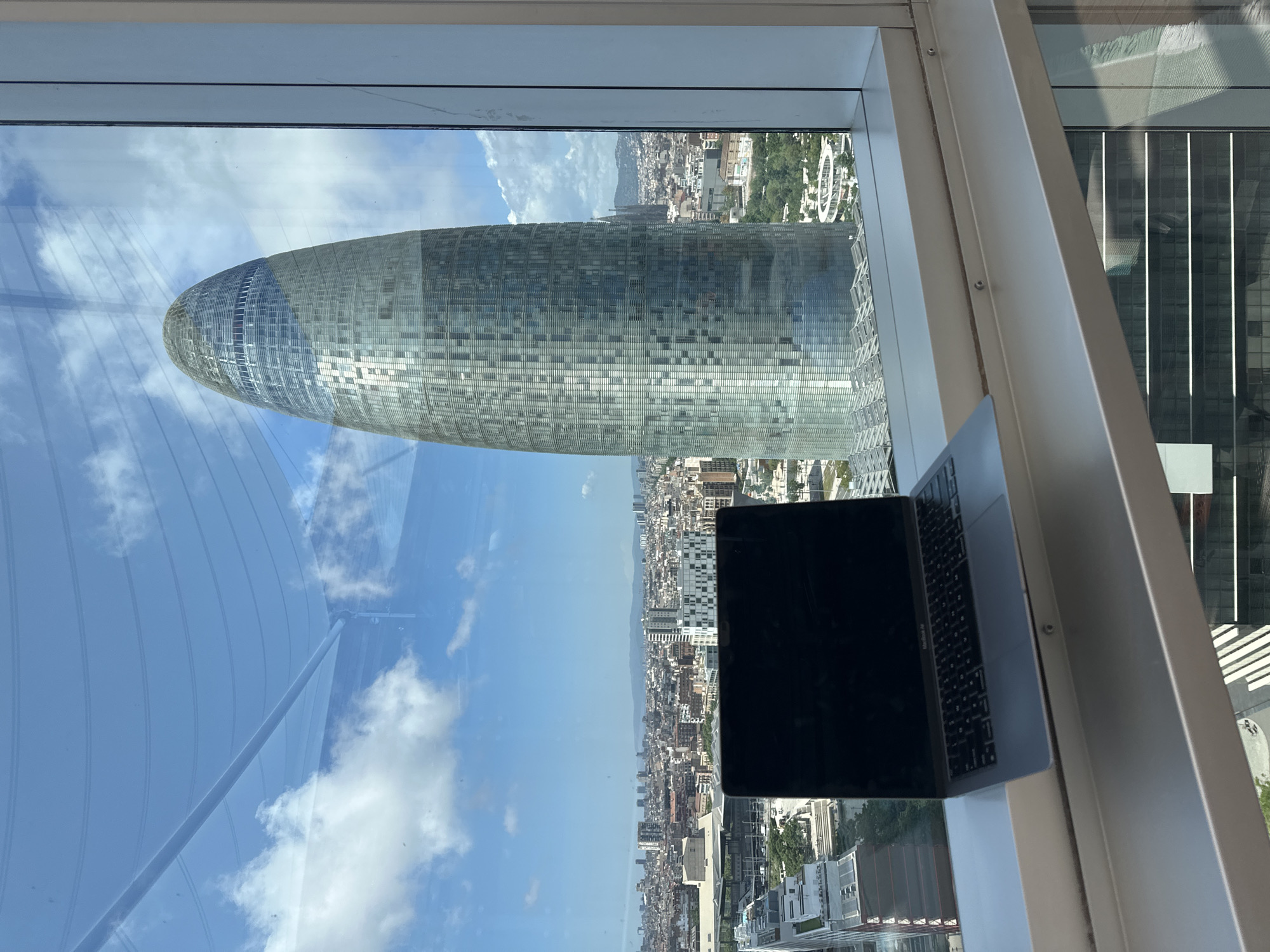 Laptop workstation captures Barcelona skyline view with Torre Glòries