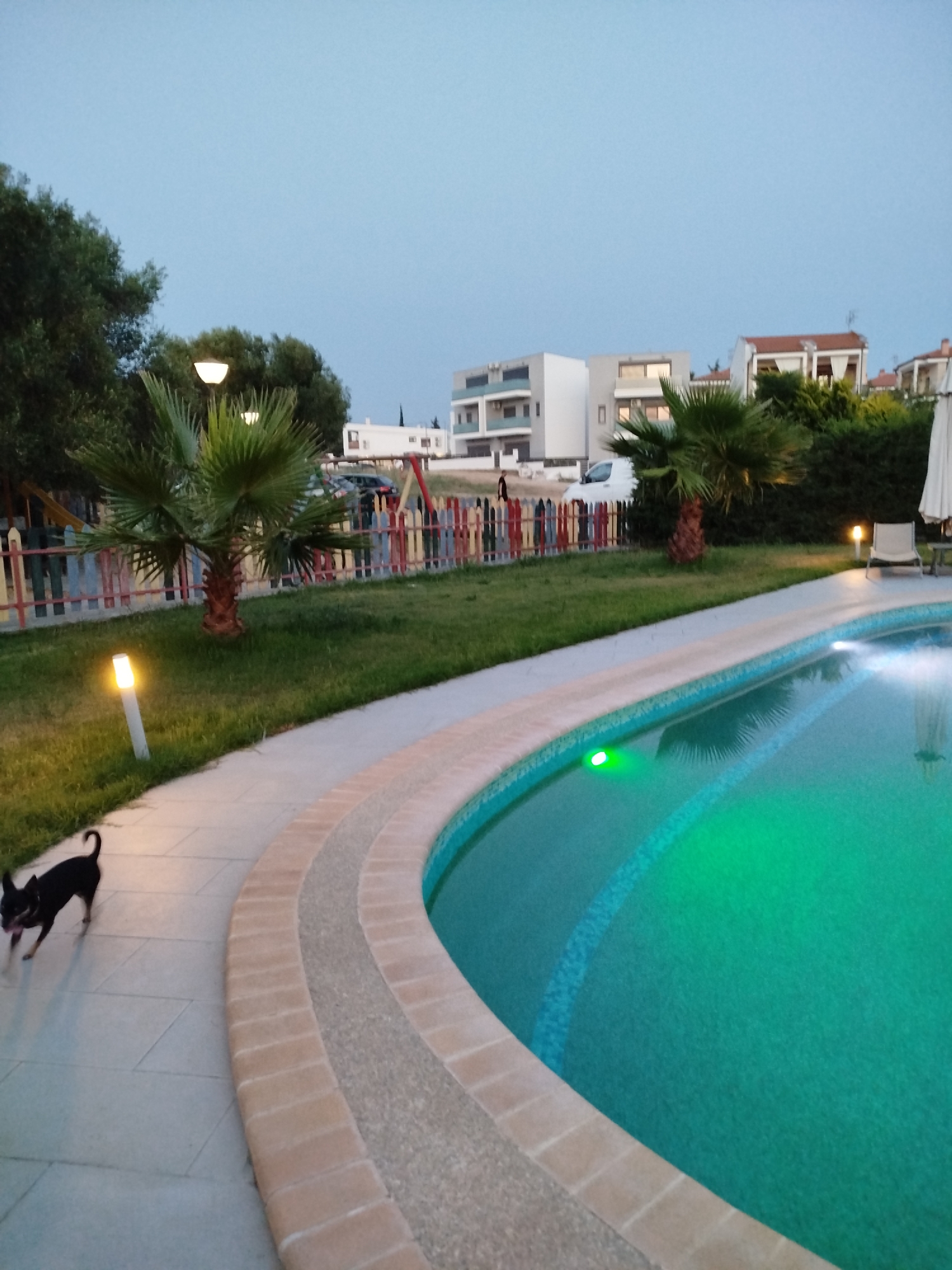 Sithonia resort grounds at dusk, pools lit and grounds quiet