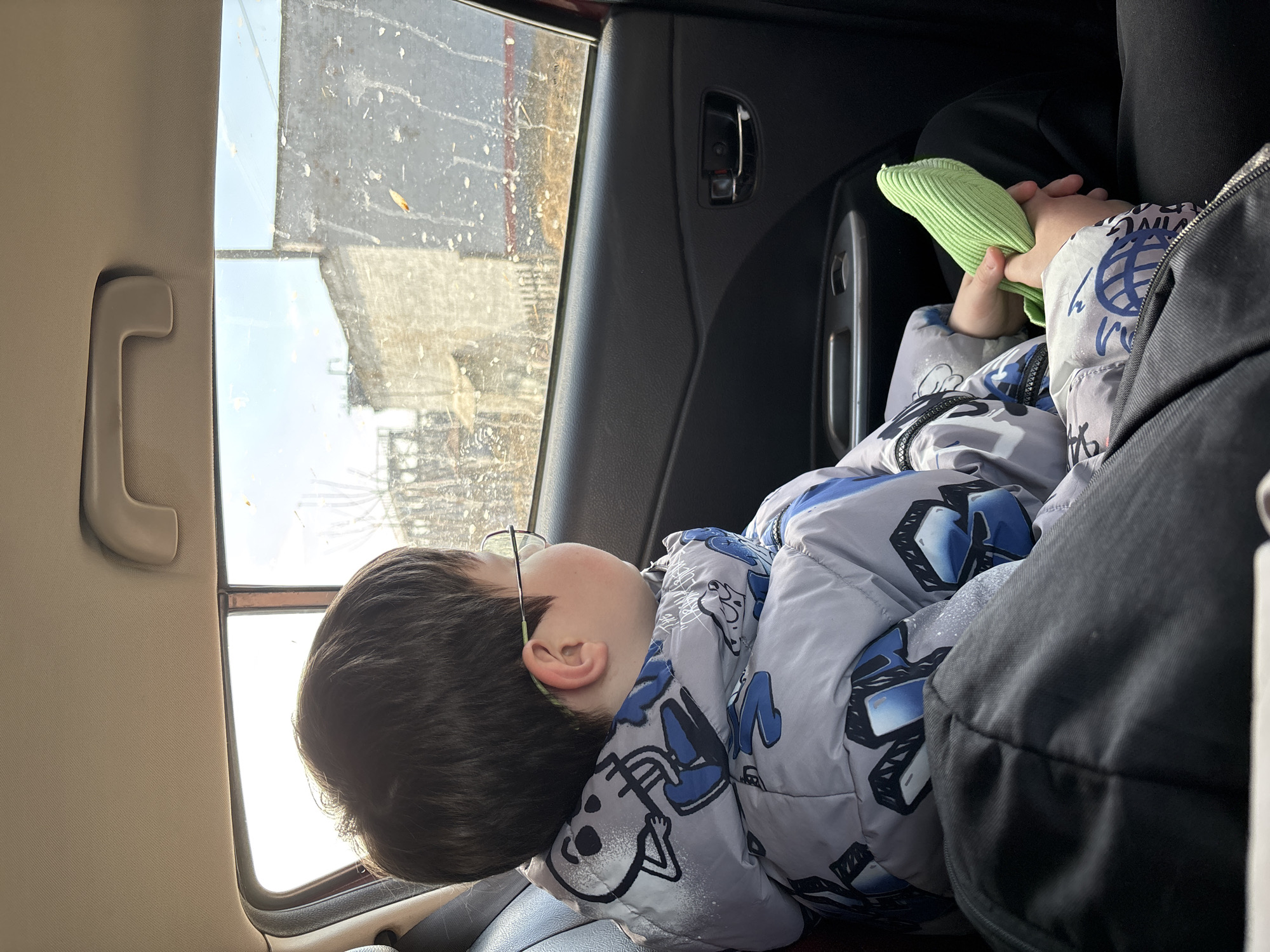 Child rests in car at railroad crossing in Russia
