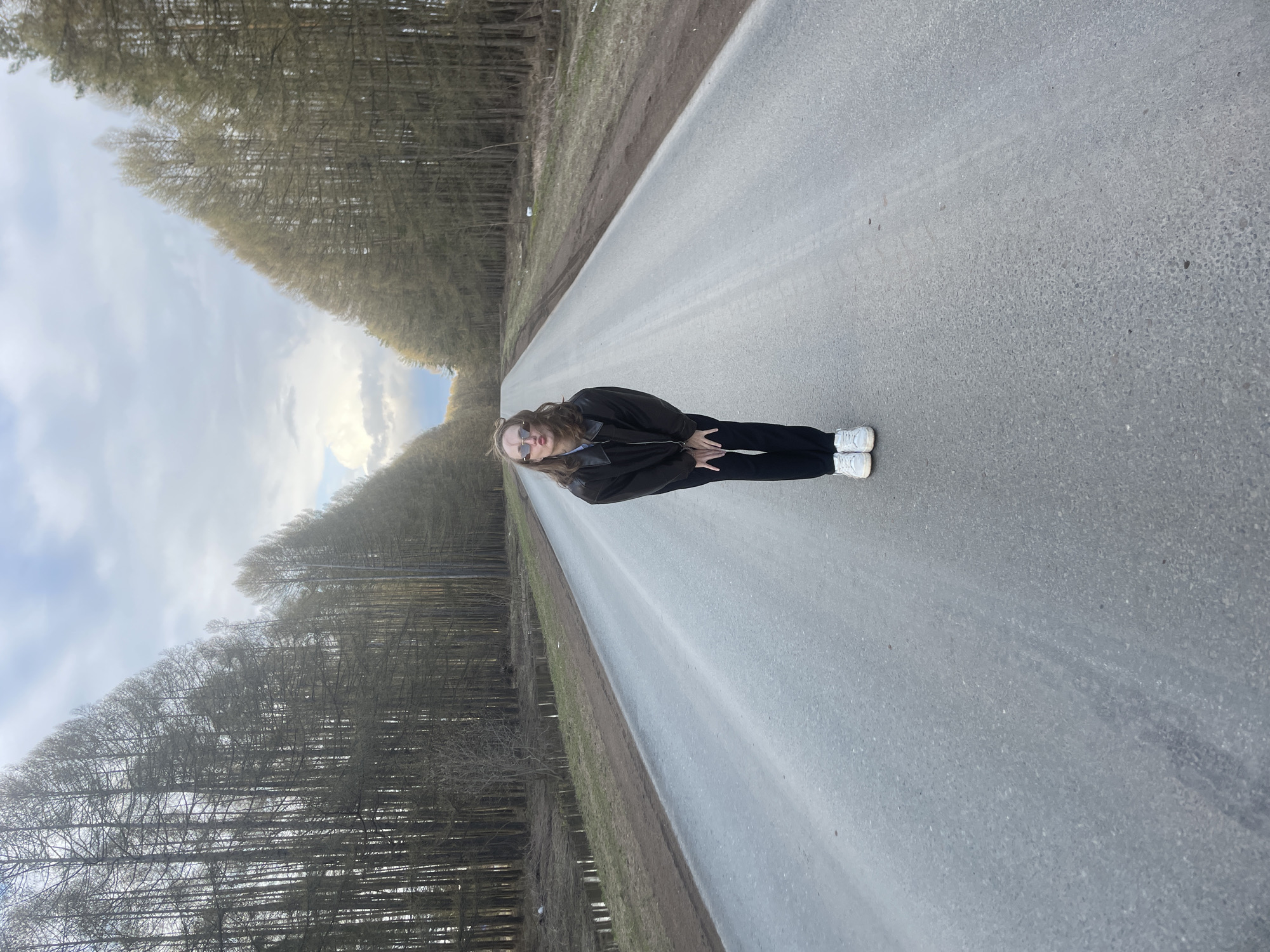 Two people photographed on tree-lined road in Podshivalovo, Russia