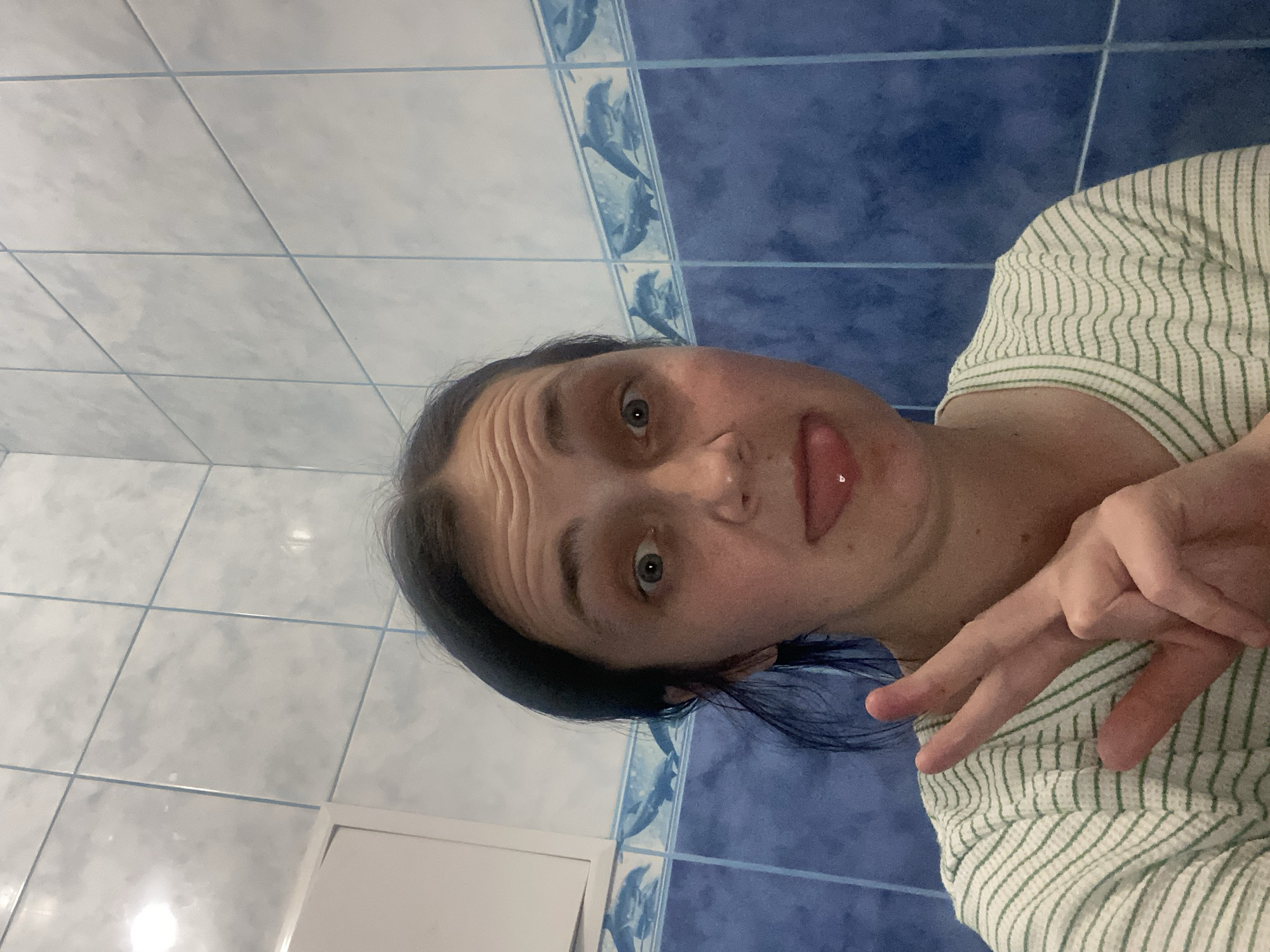 Playful selfie session at home in a striped green tee